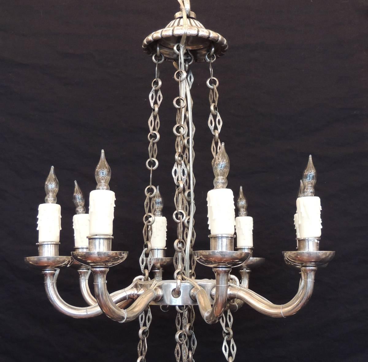 Dieser Kronleuchter wurde in der ersten Hälfte des 19. Jahrhunderts, um 1810, in Italien hergestellt und besteht aus zwei abgestuften Rängen mit insgesamt sechzehn Lichtern. Die beiden Teile werden von vier versilberten Bronzeketten getragen, die