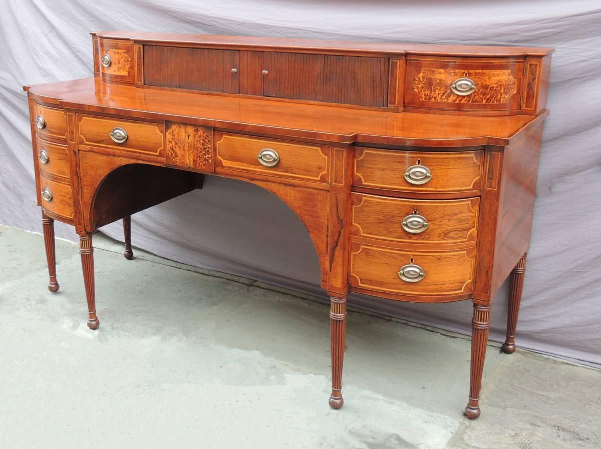 This monumental sideboard was made in Scotland, circa 1800, and features a stage top with small amboyna veneer doors bordering two tambour doors. The serving section of this sideboard is made almost entirely of veneered rosewood and features three
