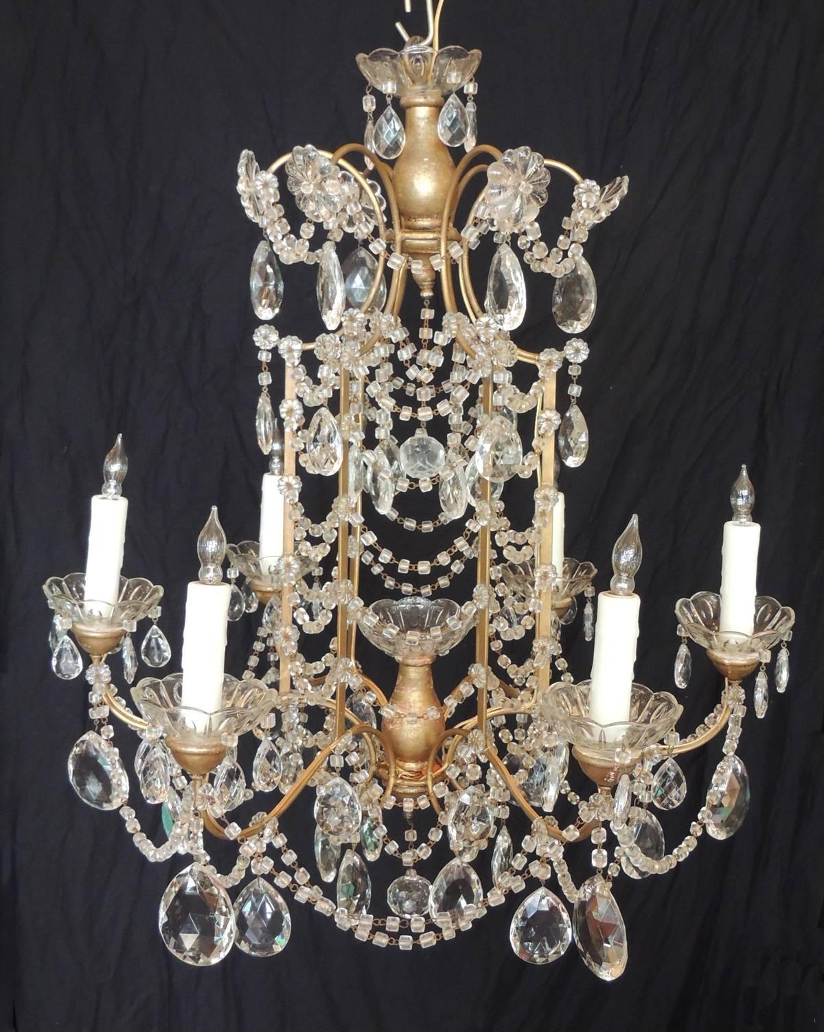 This chandelier was made in Venice in the early half of the 20th century, circa 1910. This chandelier features a top crest decorated with crystal swag and floral prisms surmounted on a pagoda form center. The chandelier has six arms decorated with