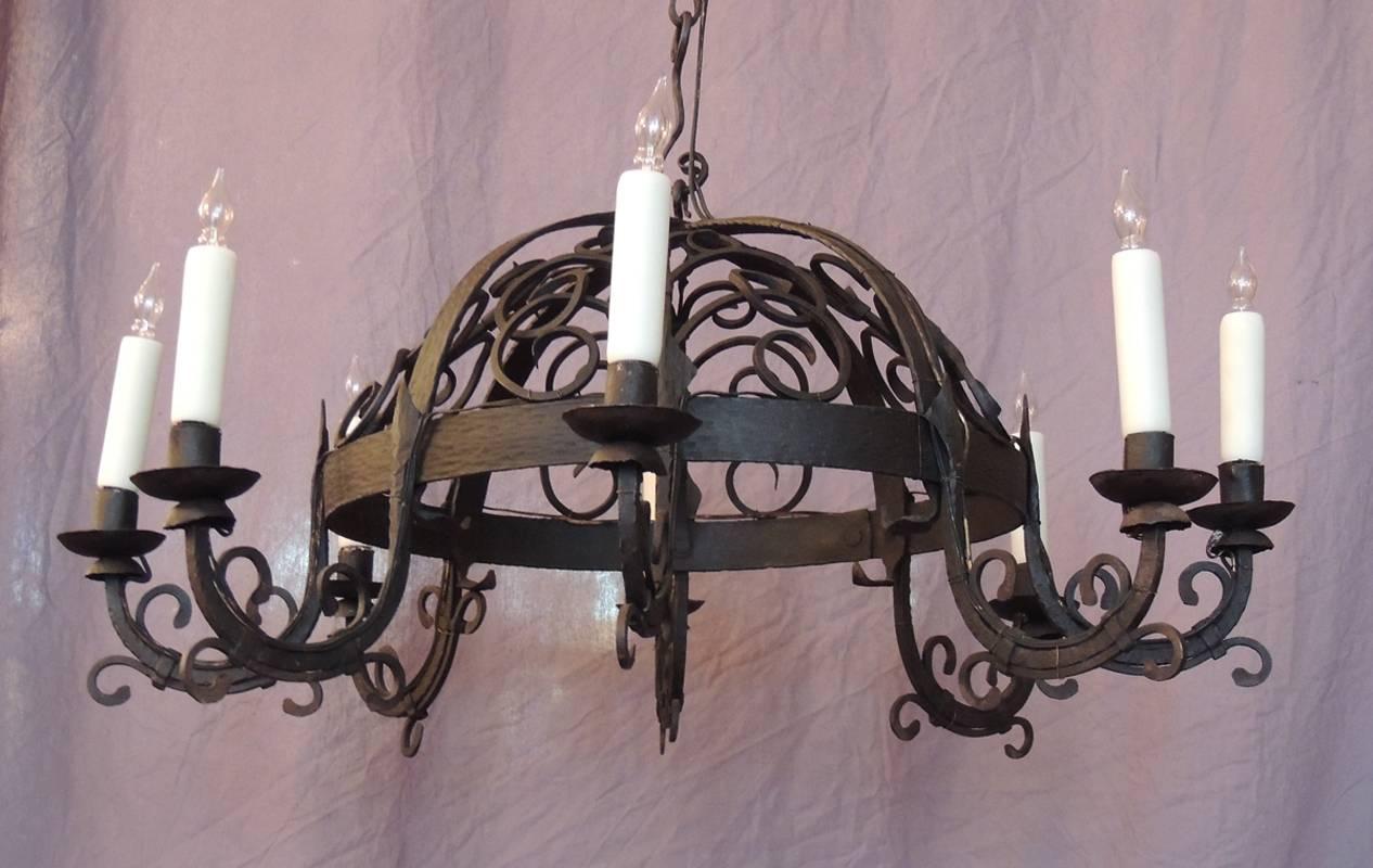 This chandelier was made in France in the mid-19th century, circa 1840. This eight armed chandelier features a dome top with scroll decoration. This chandelier was originally candle but has been wired for electricity with new porcelain sockets.