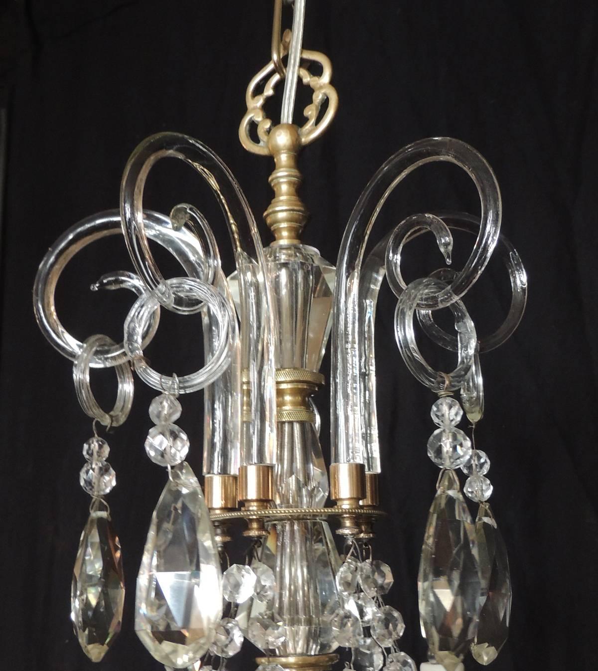 This chandelier was made in France in the early-20th century, circa 1920. This fixture is made of baccarat quality crystal with bronze doré stem and bobeche. This is a five-arm chandelier that has been rewired with new porcelain sockets.