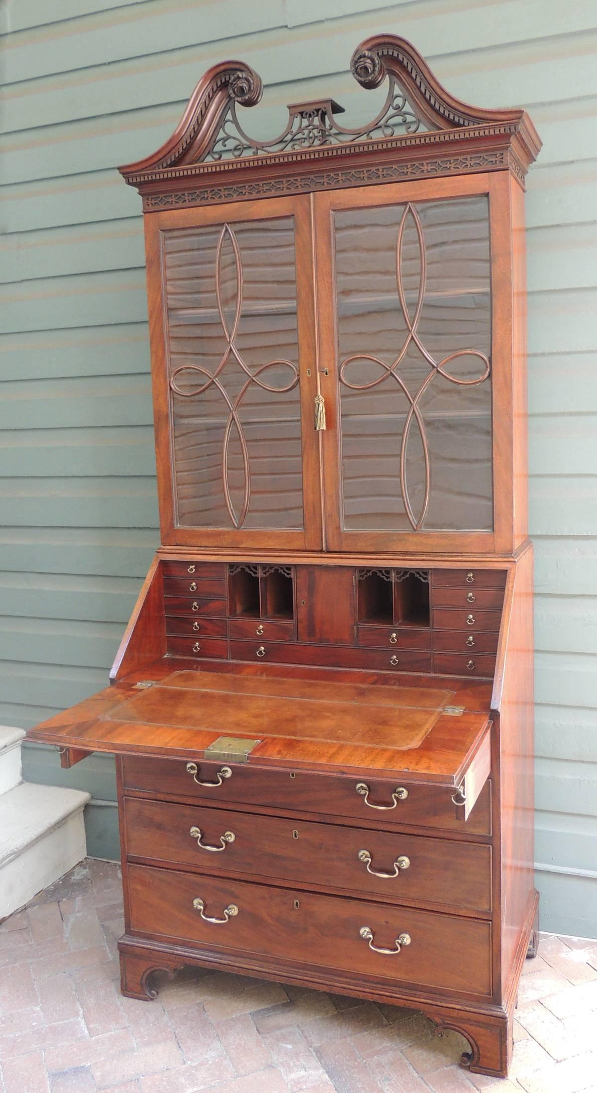 This secretary was created in England in the mid-18th century, circa 1760. The piece has a top broken pediment with pierced fretwork surrounded by dental molding ending in a carved rosette. The pediment sits on top of a dental molding detail sitting