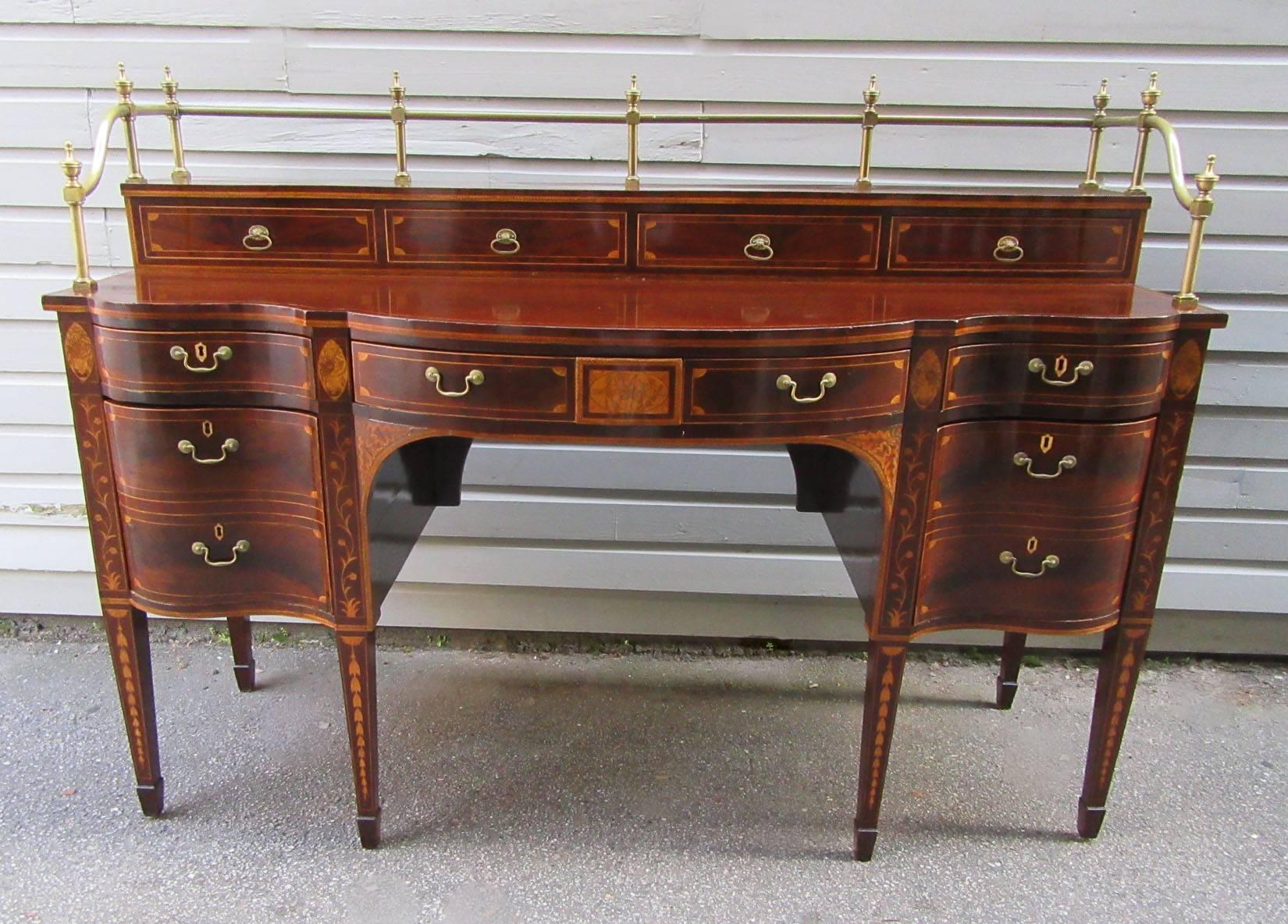 An outstanding English Georgian Hepplewhite mahogany stage back sideboard, circa 1790, with exceptional tulipwood and satinwood inlay, seven storage drawers, opposing cellarette drawers and brass gallery surround.