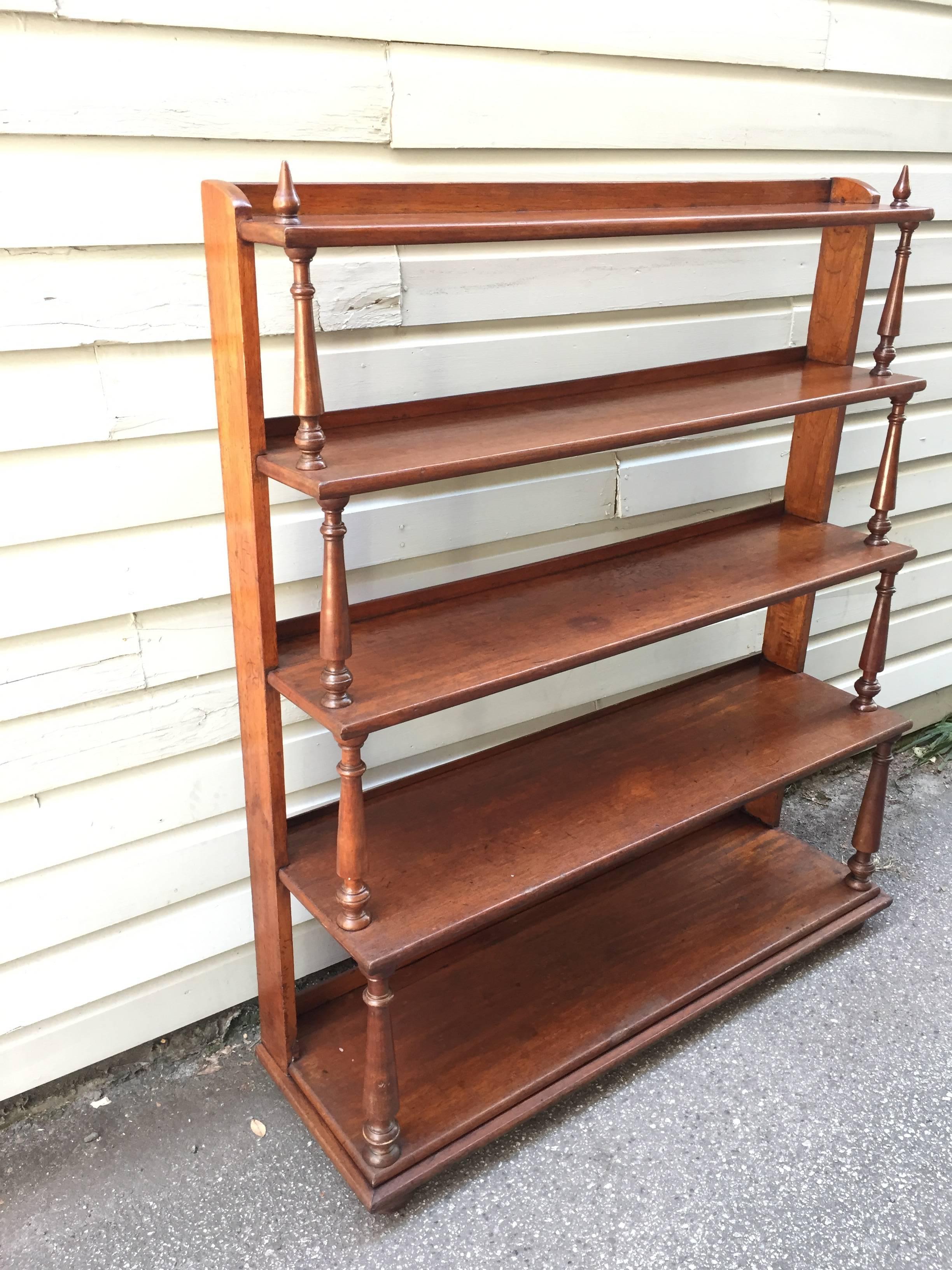A circa 1820 bookcase from Barbados that reflects the West Indies/British Colonial style made from solid cedrela, featuring five shelves and pointed finials on top. This bookcase is published in a book documenting Caribbean antiques title 