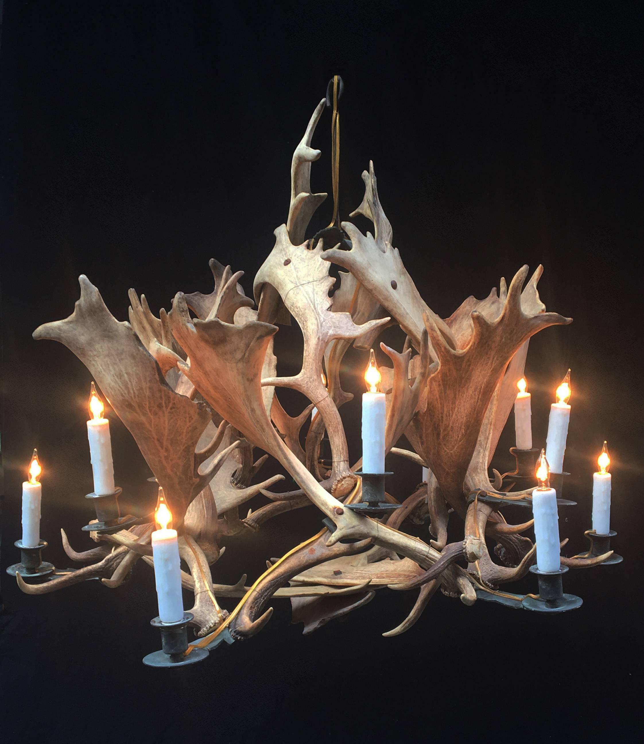 A chandelier made from shed antlers that was originally candle, since electrified, circa 1850. The candleholders are hand-wrought bronze and display 12 lights.