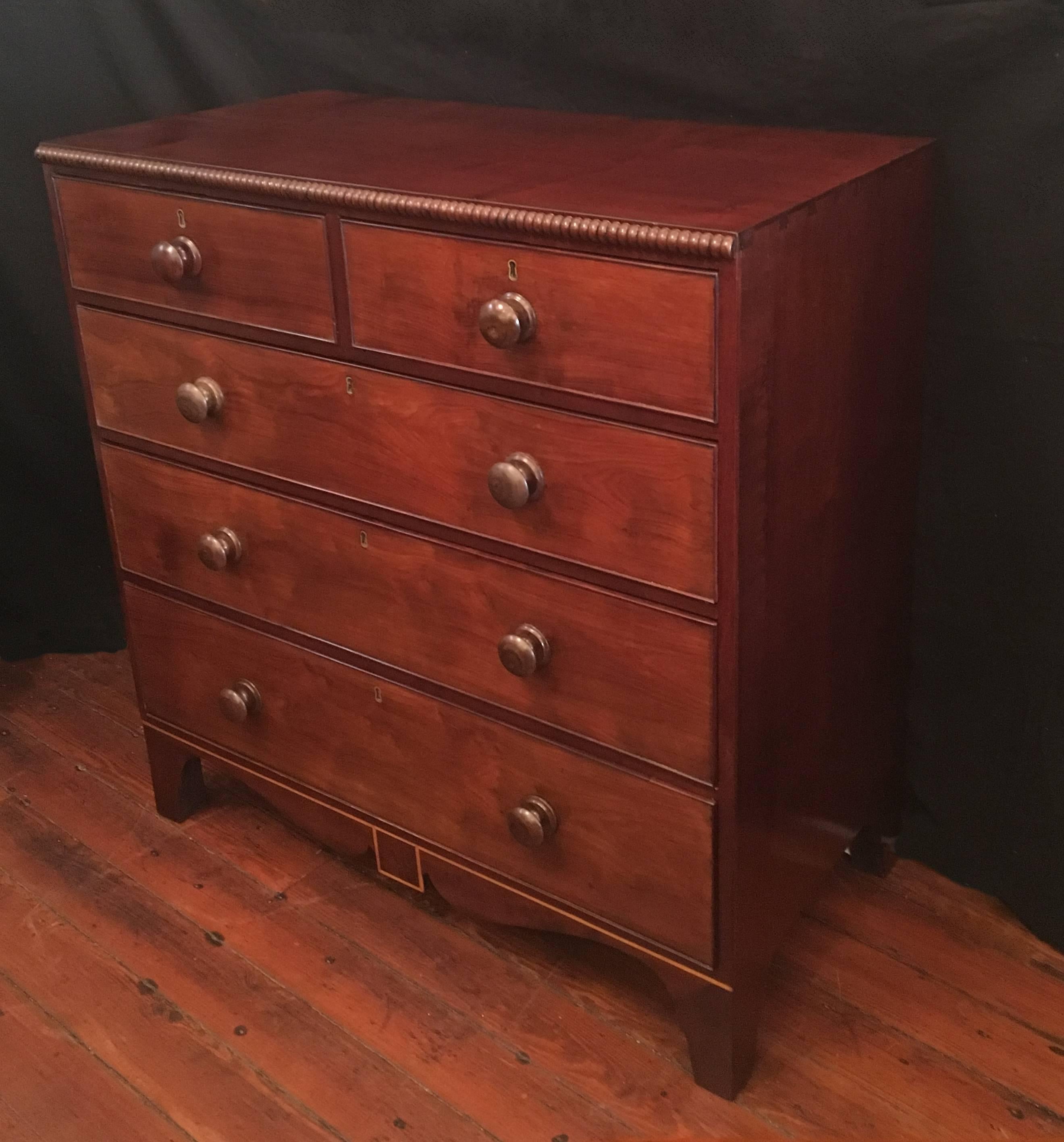 Very rare British Colonial Jamaican chest made out of solid mahogany and cedrela. The chest has satinwood inlay on the bottom rail framing a figured mahogany cartouche with unusual French style bracket feet with Jamaican spur. There is a spool
