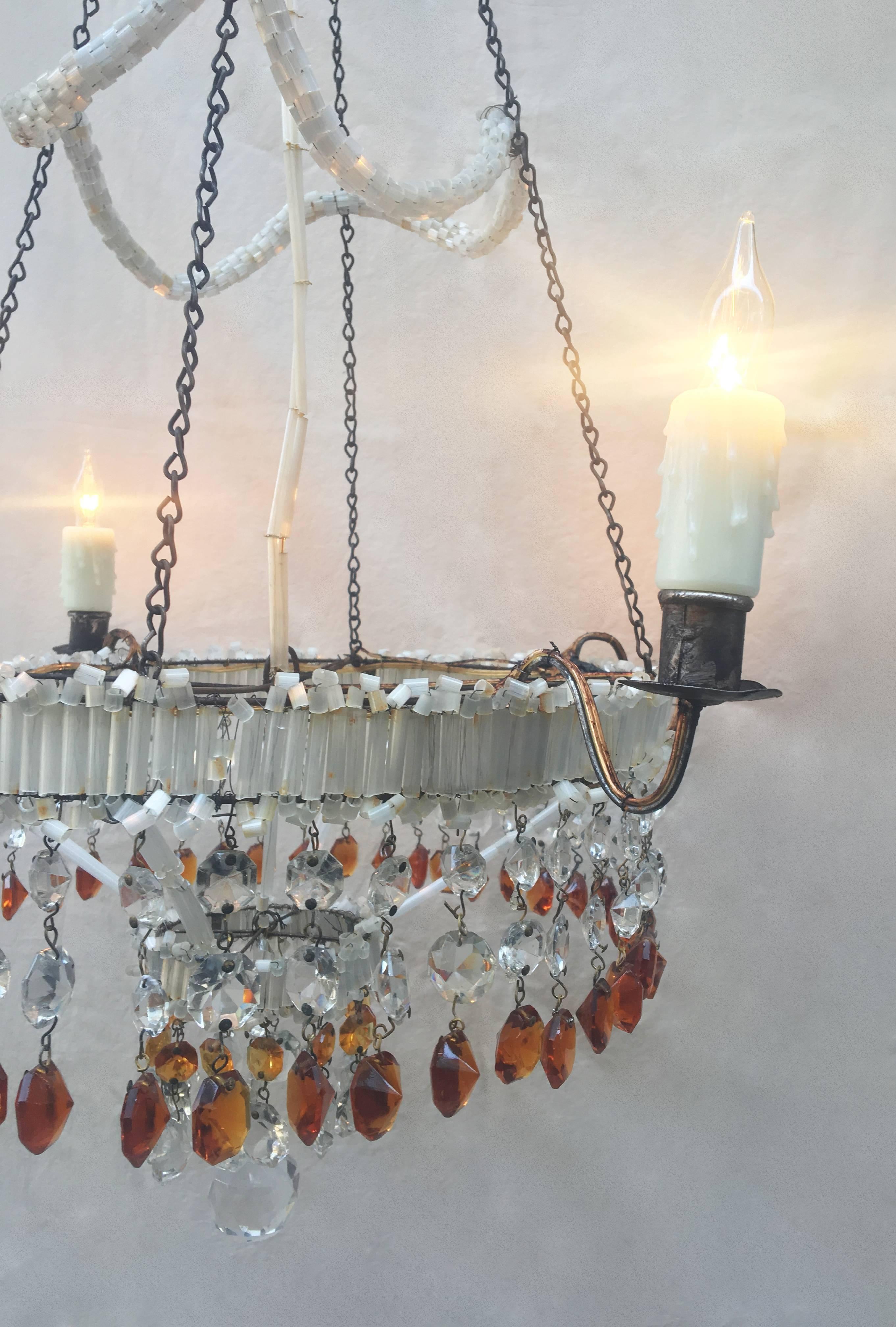 This 19th century Italian Empire chandelier is beautifully decorated with Venetian Opaline glass. The four arms are made of brass. Amber crystals suspend from the bottom. This item has been rewired and electrified. 

This chandelier comes with