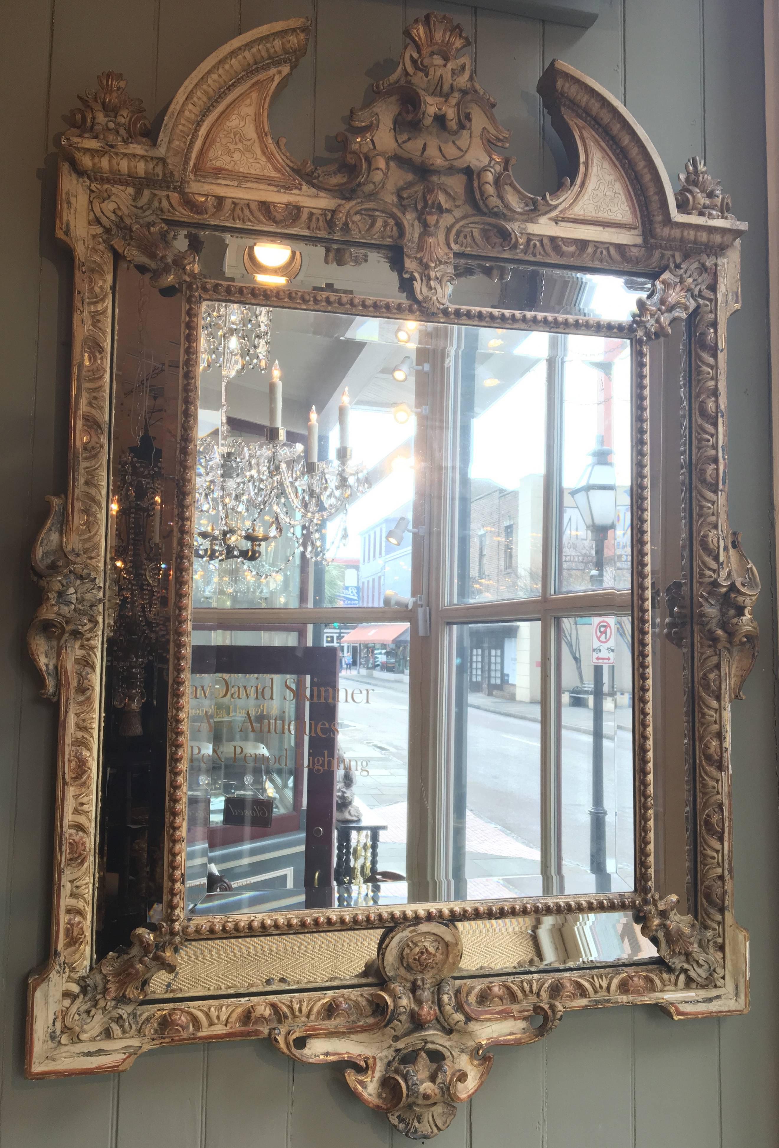 This 19th century Italian Baroque wood carved mirror has original paint with beautiful gilt highlights.