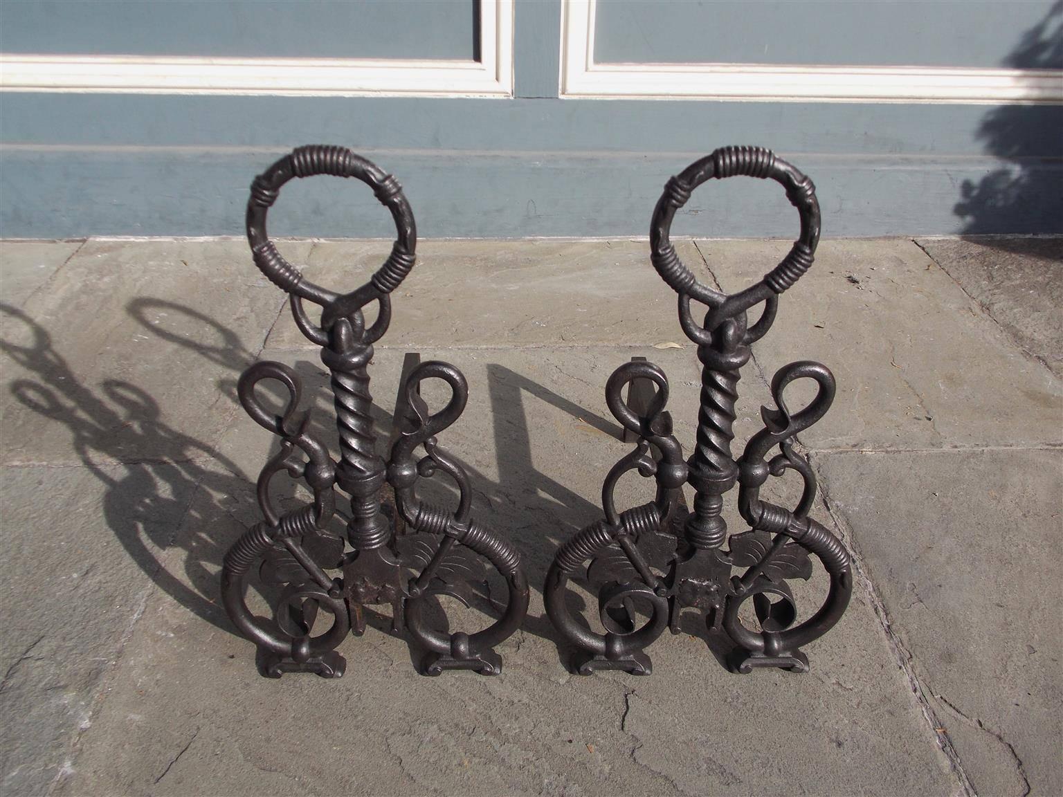 Pair of American cast iron andirons with a circular ring finial, intertwined vine, twisted center column on ringed squared plinth, decorative scroll work, and terminating on original bracket feet, Mid-19th Century.  