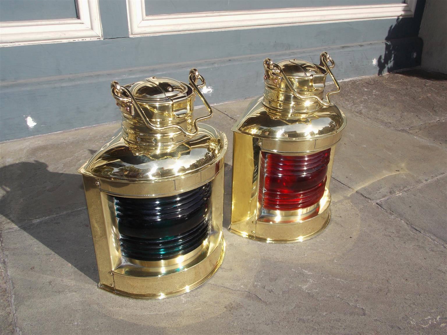 Pair of American port and starboard solid brass Perko ship lanterns with the original Fresnel colored lenses, vented tops, carrying handles, and original side mounting brackets, Early 20th century, Brooklyn, NY.