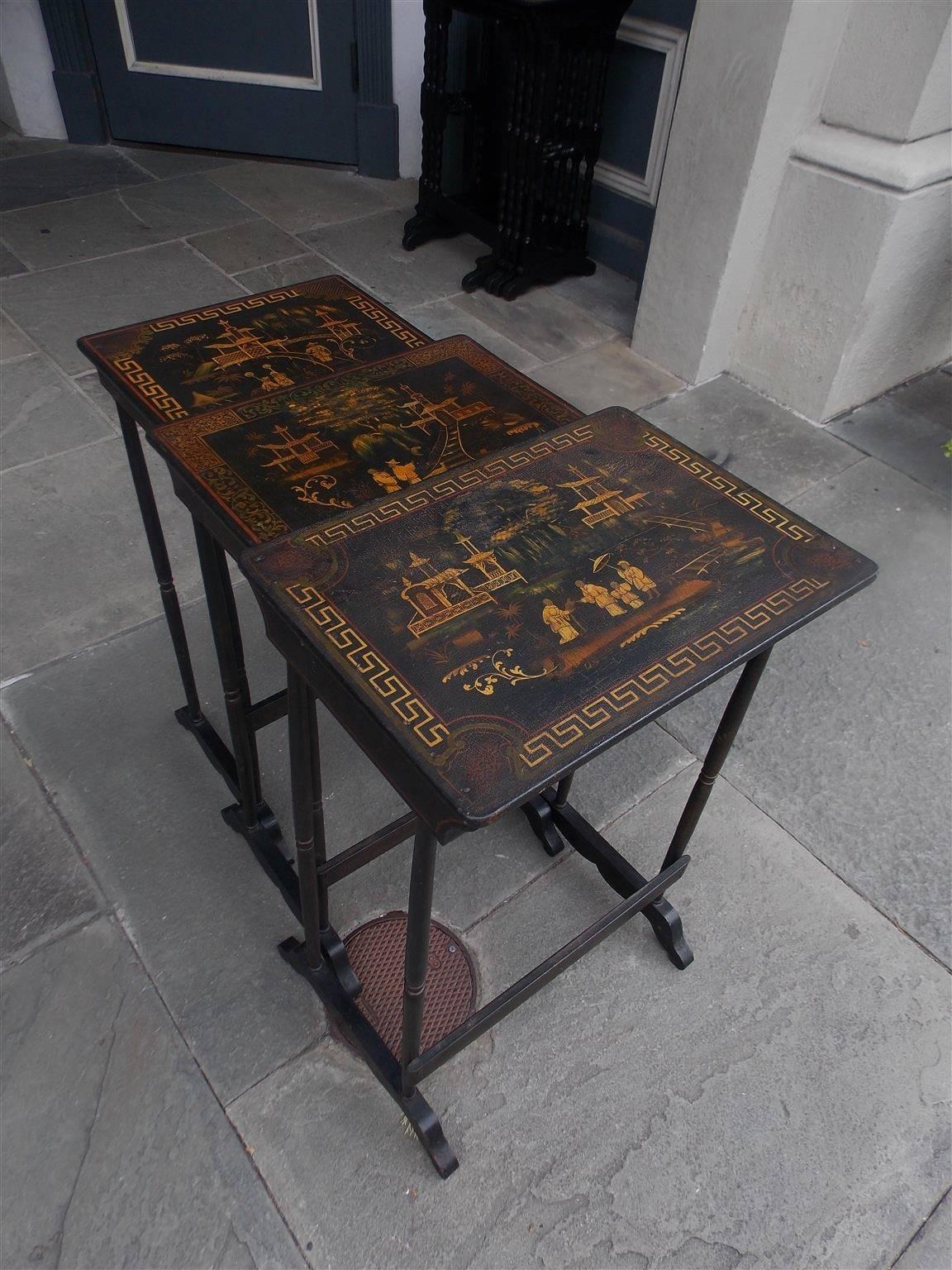 Set of three English Japanned nest of tables with figural gilt stenciling, pagoda, foliage and Greek key motif. Tables are rectangular in shape and have turned ringed legs with connecting stretchers, Late 19th Century.