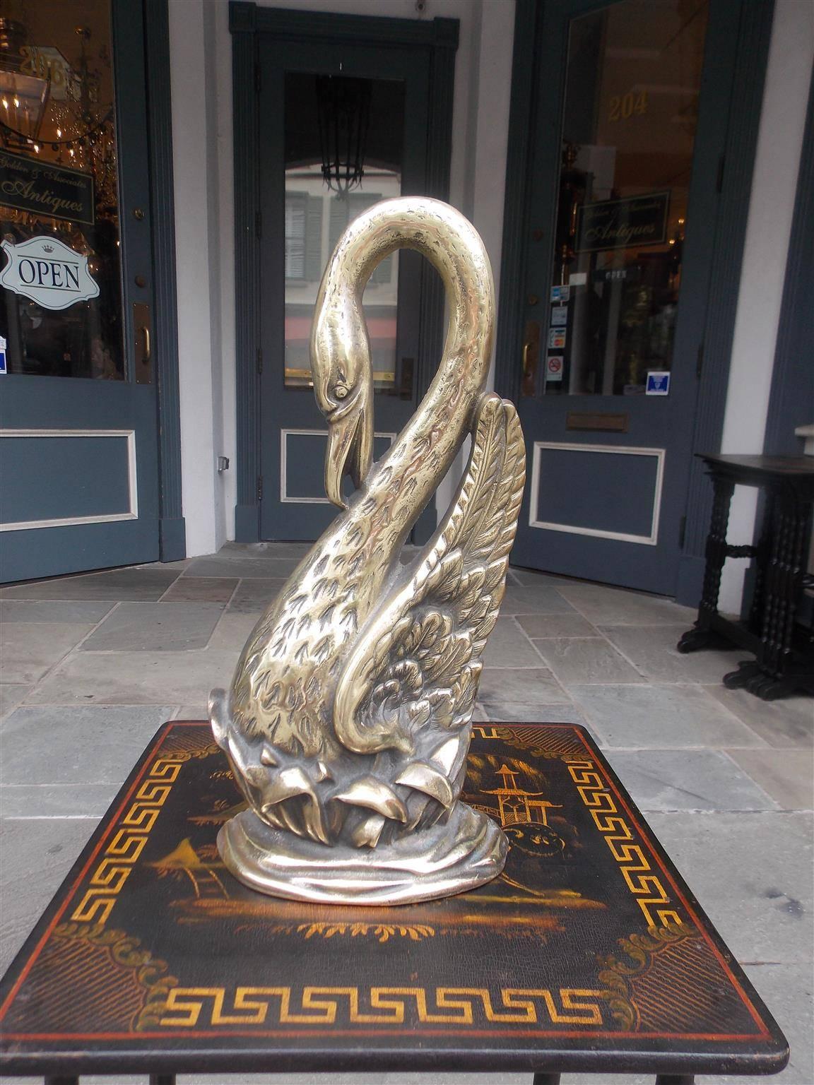 American brass preening swan doorstop resting on marsh grass and water motif, Late 19th Century.