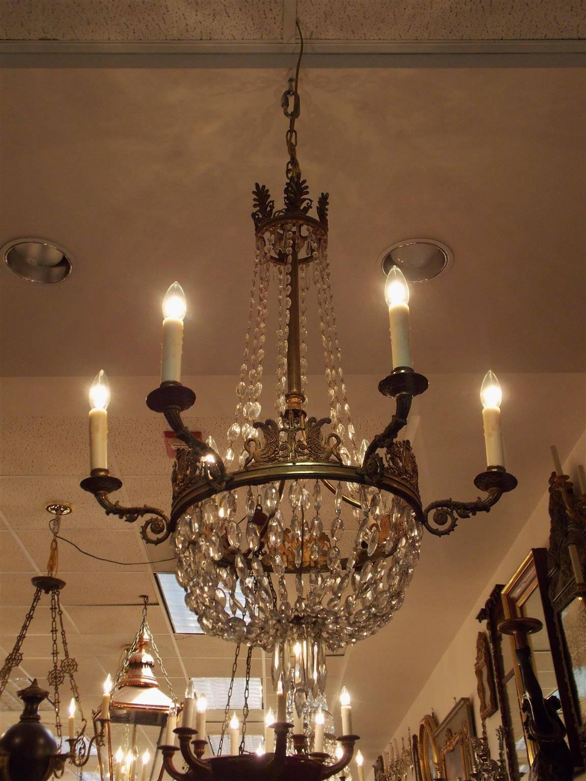 English Regency gilt bronze six-light chandelier with chased filigree canopy, cascading centered graduated crystals, alternating tridents flanked by swan motif, alternating lyres flanked by cornucopia motif, foliage chased medallion scrolled arms