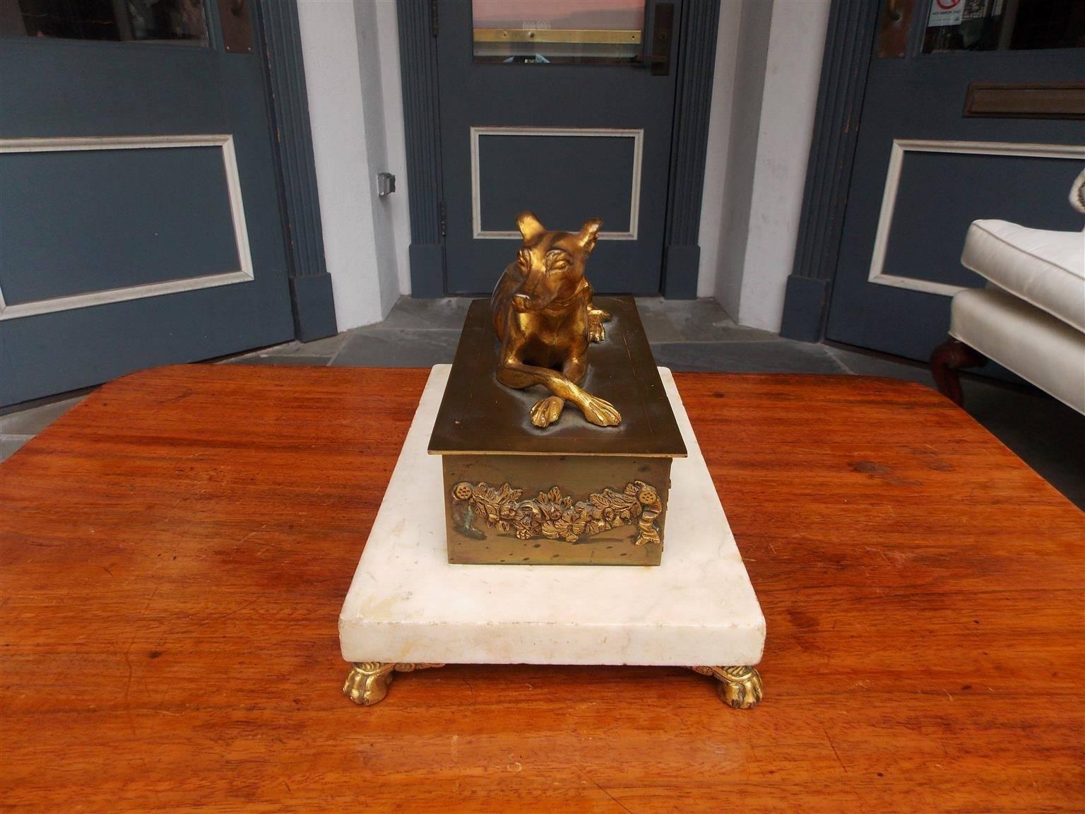 English Regency bronze ormolu whippet inkwell with flanking figural canines, floral swag motif, and resting on rectangular marble base with the original ormolu lions paw feet, Early 19th century.