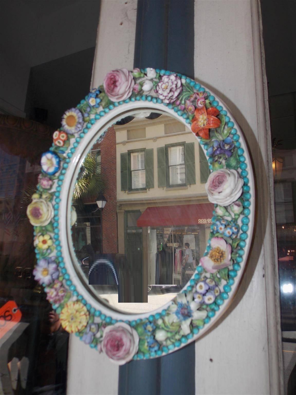 English Derby oval mirror with vibrant bead work and decorative porcelain flowers. Mirror retains the original beveled glass and paper label on back, Early 19th Century.