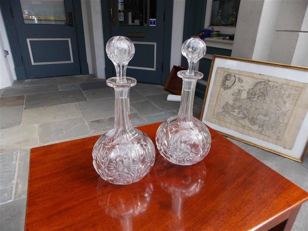Pair of American cut crystal bulbous fluted floral decanters with the original blown stoppers, Early 19th century.