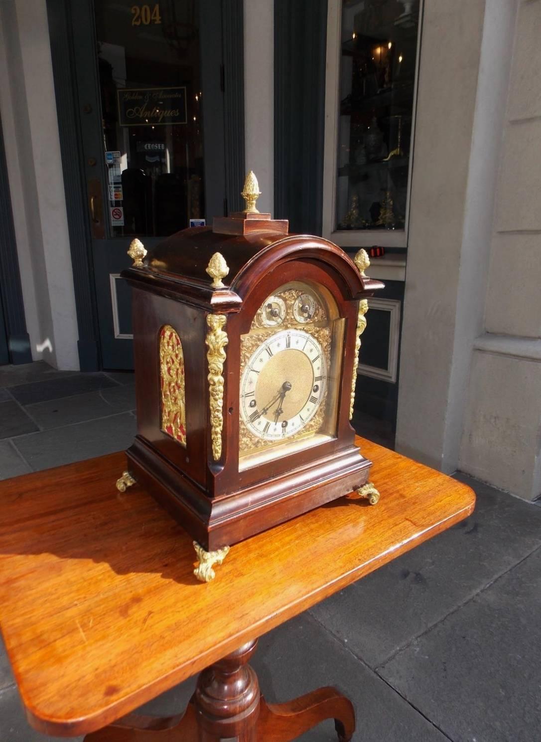 German mahogany and ormolu bracket clock with gilt bronze pineapple finials, flanking figural floral corner mounts, arched floral side screens, hinged astragal shaped glass door with steel engraved face housing a three train movement striking