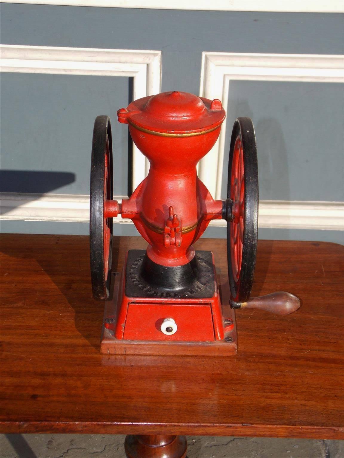 American cast iron and painted single drawer coffee mill with a porcelain knob, swivel lid, circular rotating wheels and the original wooden handle. Stamped by maker Enterprise Mfg Company, Philadelphia, Circa 1888. Mill is in working condition.