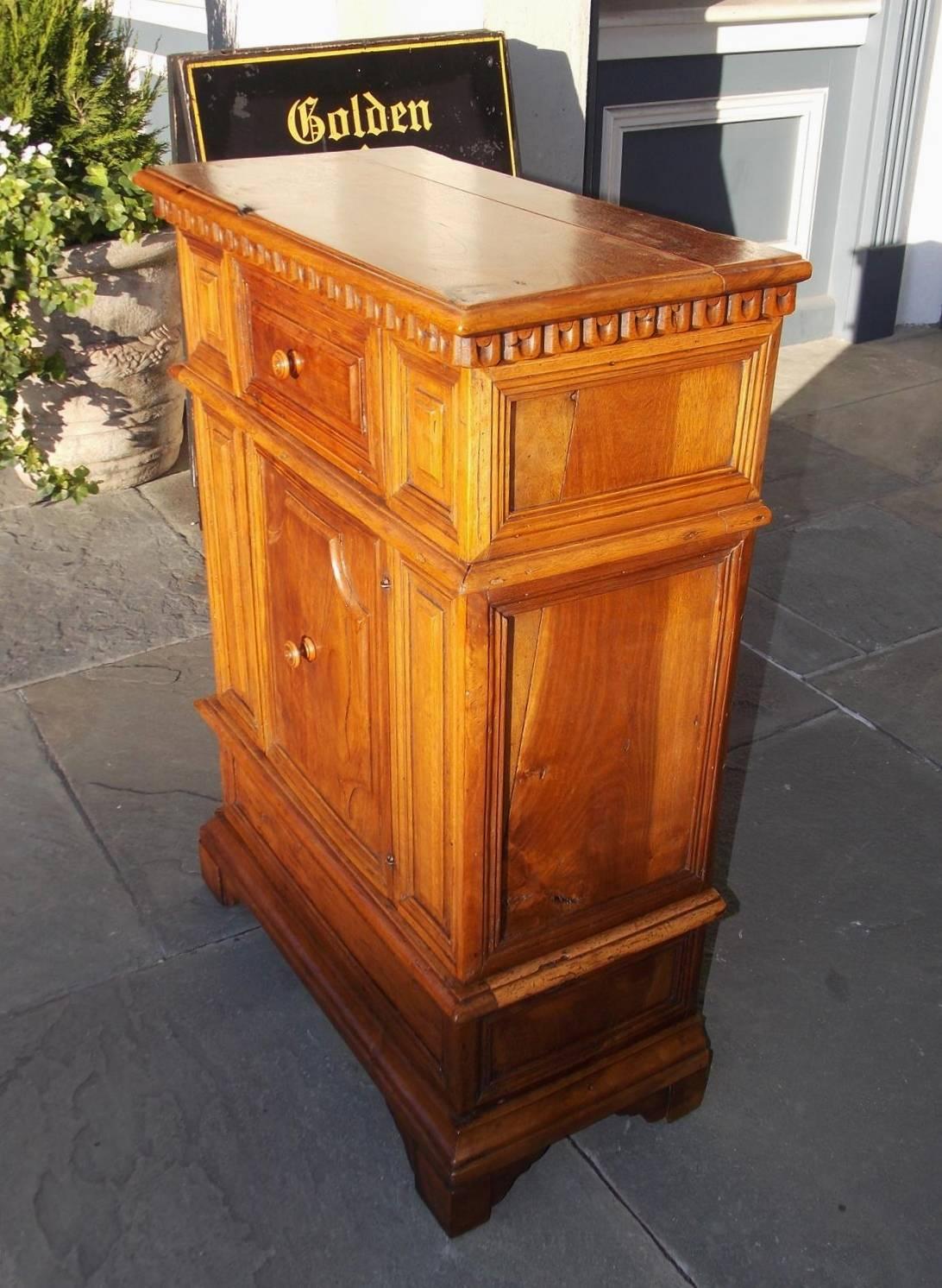 Italian walnut Rococo cupboard with a carved molded edge top, decorative incised carvings, upper single drawer and a lower cabinet with the original wooden knobs, original locking mechanism, and terminating on the original bracket feet. Secondary