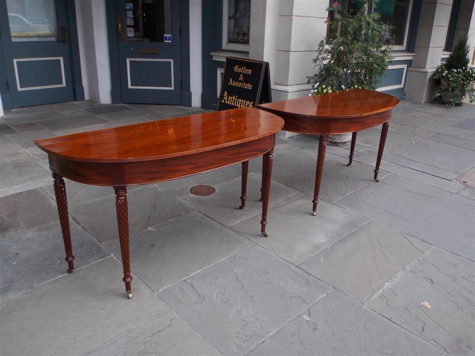 Pair of American Regency mahogany D-ends with one board tops, carved molded skirts, fluted corners, terminating on turned ringed barley twist legs with the original brass casters, Early 19th Century.