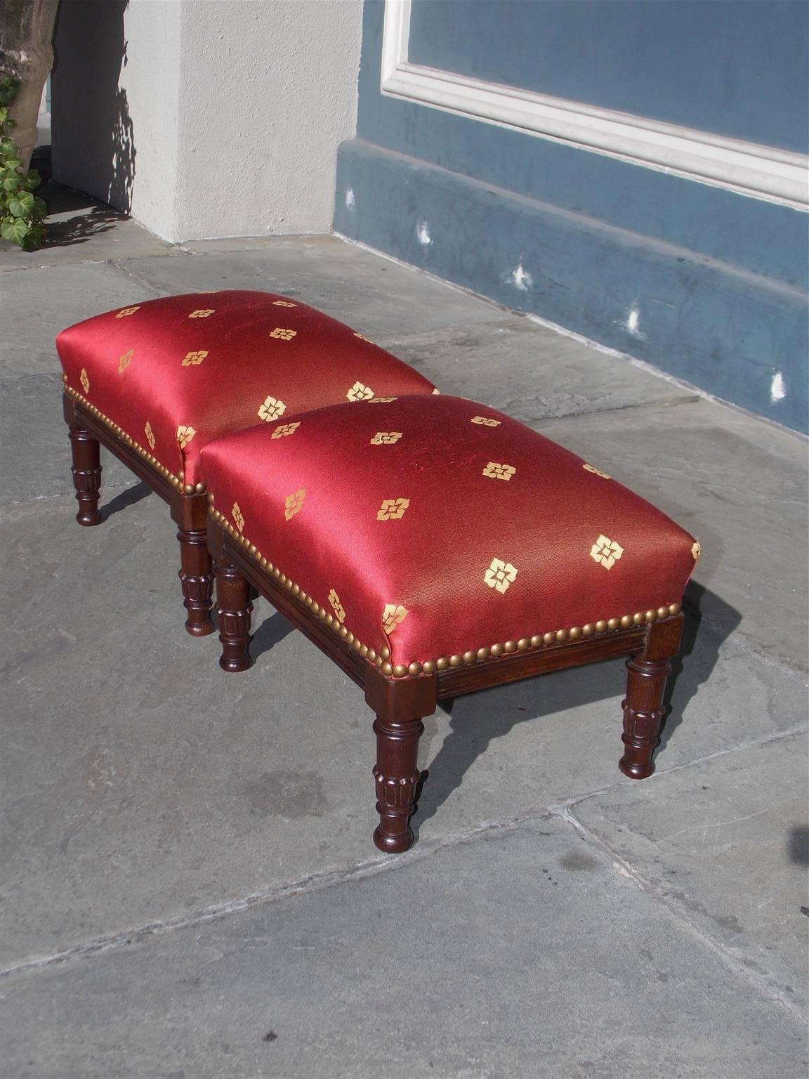 Pair of American mahogany Classical foot stools with floral silk upholstery, brass tacks, and resting on turned carved ringed legs, Early 19th century.
