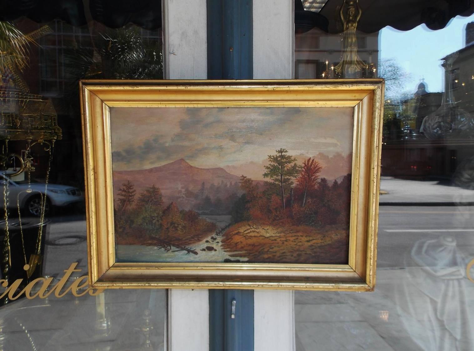 American school oil landscape on academy board in the original gold gilt molded frame. Landscape depicts Hudson Valley with mountains in the background, trees in the foreground and a flowing rocky stream, Early 19th century. Inscribed Mrs. Demming