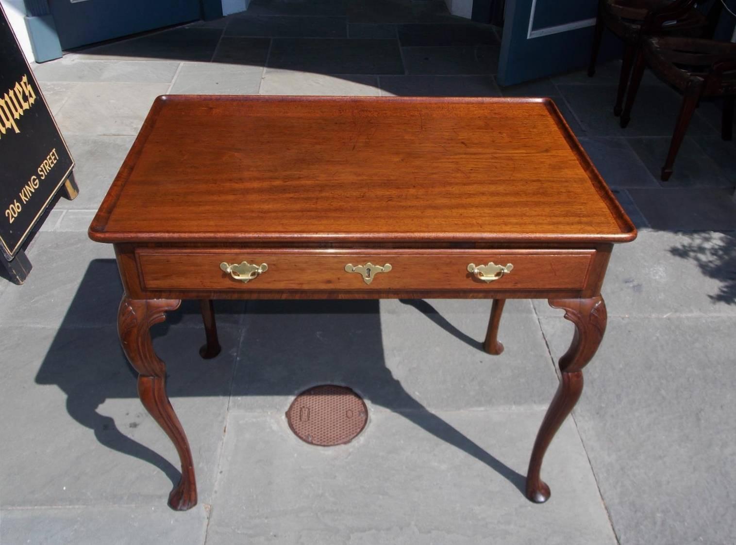 English Chippendale mahogany dish top tea table with a centered single drawer, period brasses, carved shell knees, inset legs , and terminating on four stocking feet, Mid-18th century. Secondary wood consist of oak throughout.