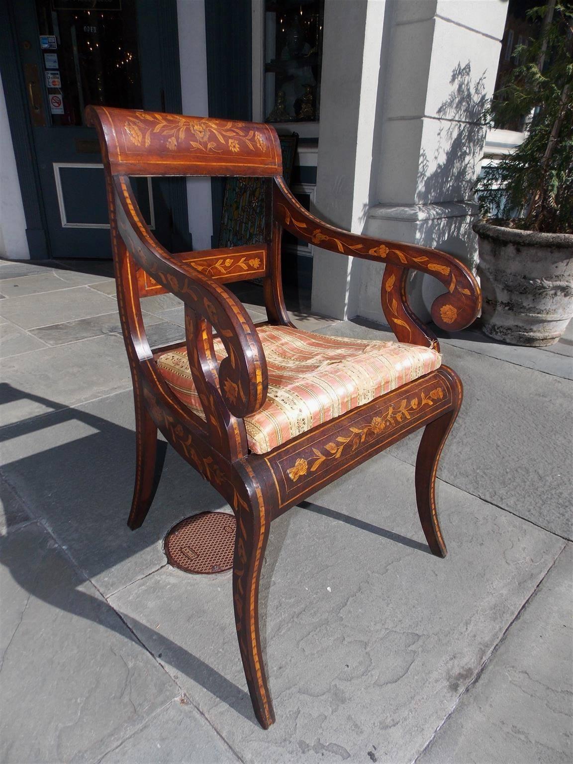 Italian walnut marquetry armchair with decorative floral tulip inlays, flanking scrolled arms, upholstered muslin seat, and terminating on saber legs. Seat is upholstered in white muslin, Early 19th Century.