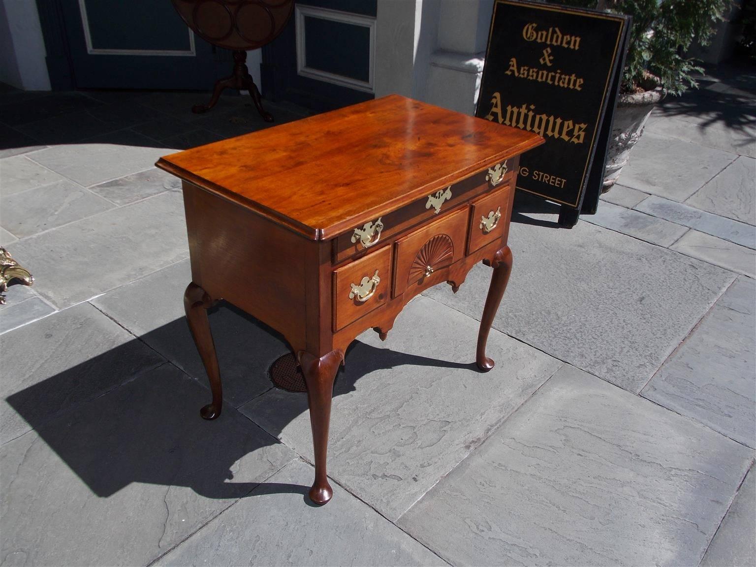 American Queen Anne walnut fan-carved lowboy with a molded edge top, period brasses, carved arched pointed apron, and terminating on graceful tapered pad feet, Mid-18th Century, Connecticut. Secondary wood consist of white pine throughout.
