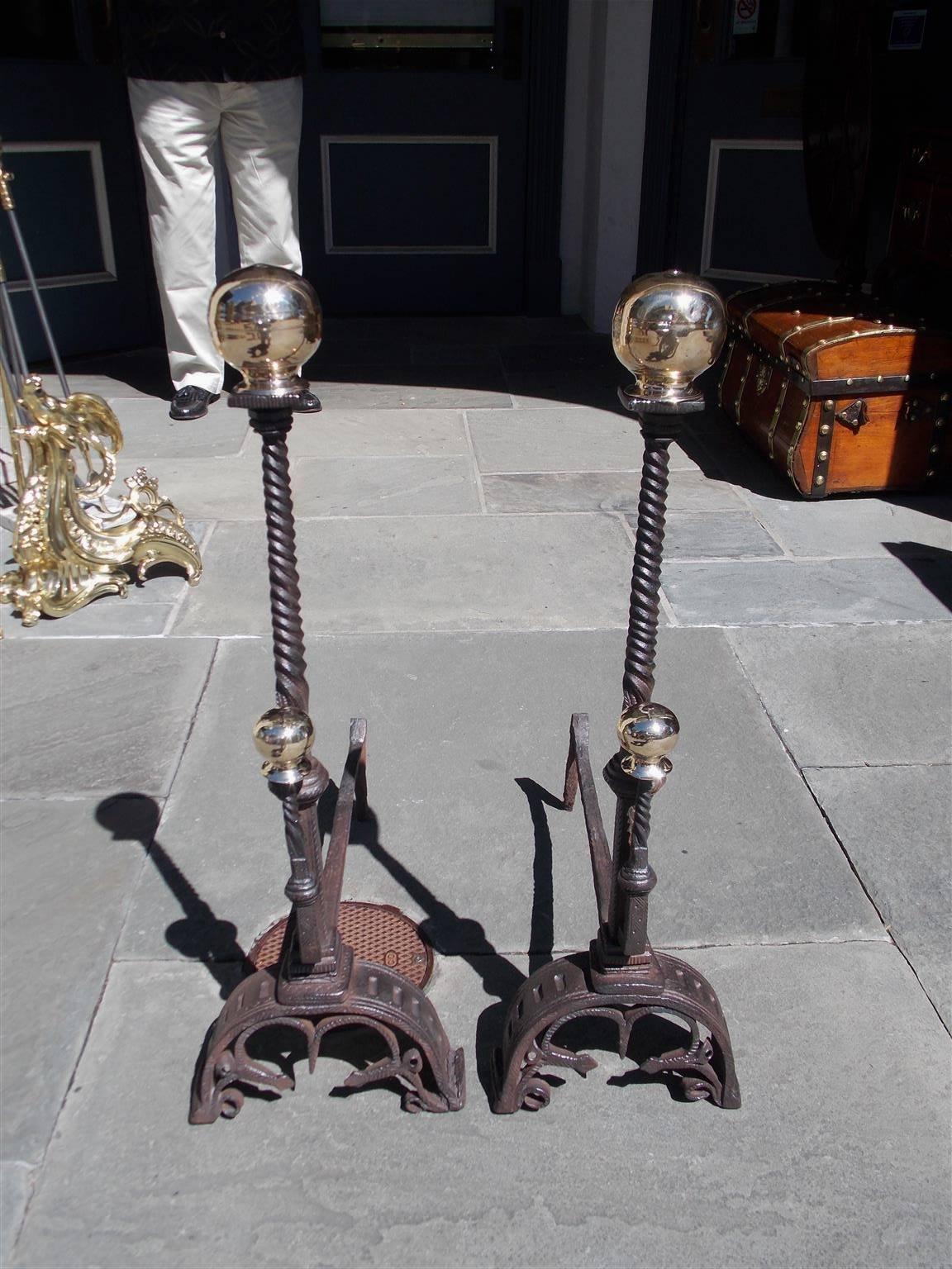 Pair of English wrought iron and brass ball top andirons with spiral twisted columns, matching brass spiral spit hooks and terminating on scrolled decorative hand chased feet, Late 18th Century.