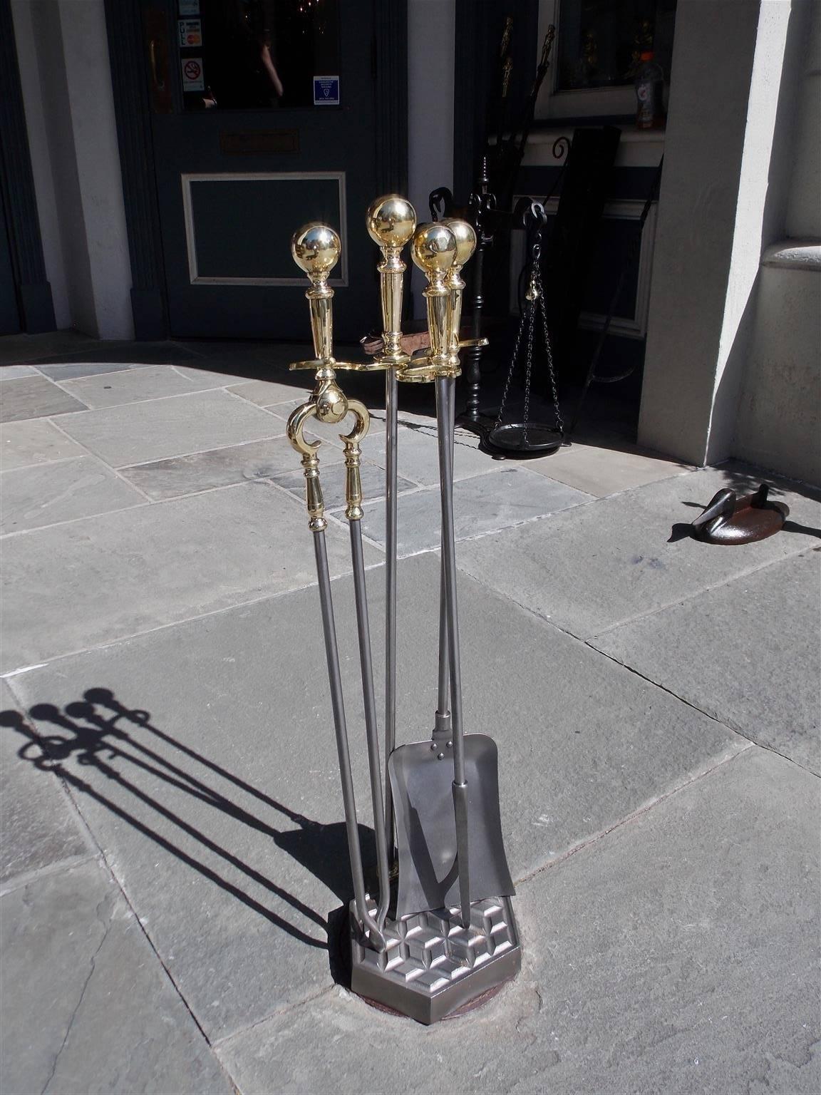 Set of American ball top polished steel and brass fire tools resting on a matching cross hatched hexagon stand, Mid-19th century. Set consist of shovel, tong, and poker.