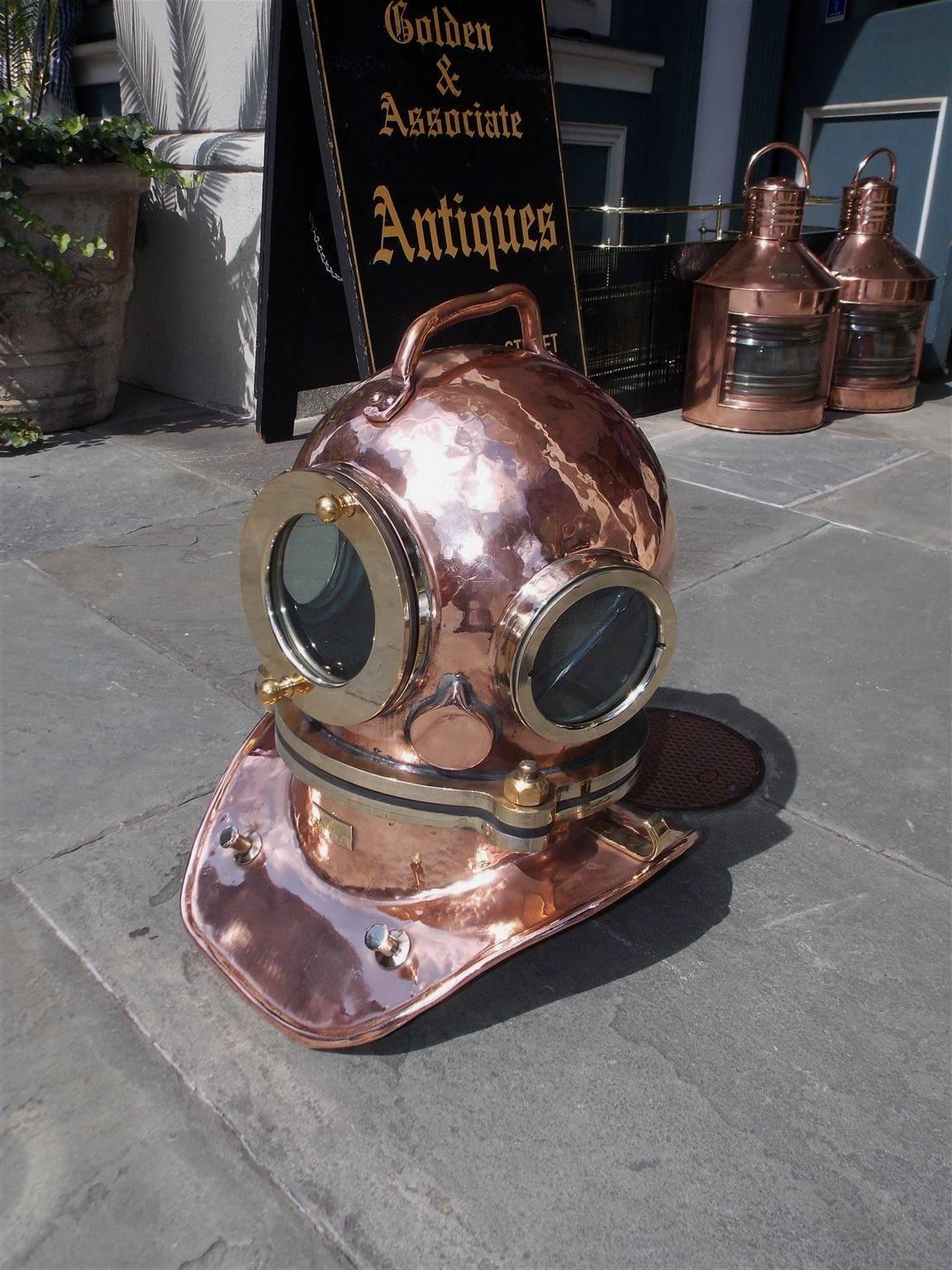 Russian maritime copper and brass deep sea divers helmet with three glass threaded windows, centered carrying handle, threaded bonnet,  air line intake, and ventilator on rear exterior. Late 20th century. 

