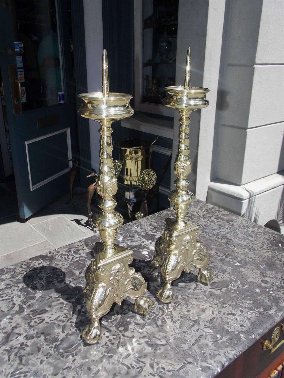 Pair of Italian brass prickets with upper ringed bobeches, centered candle spikes, turned bulbous decorative spiral floral columns, supported on triangular figural foliage beaded knee bases, with ball and claw feet. Mid-18th century.