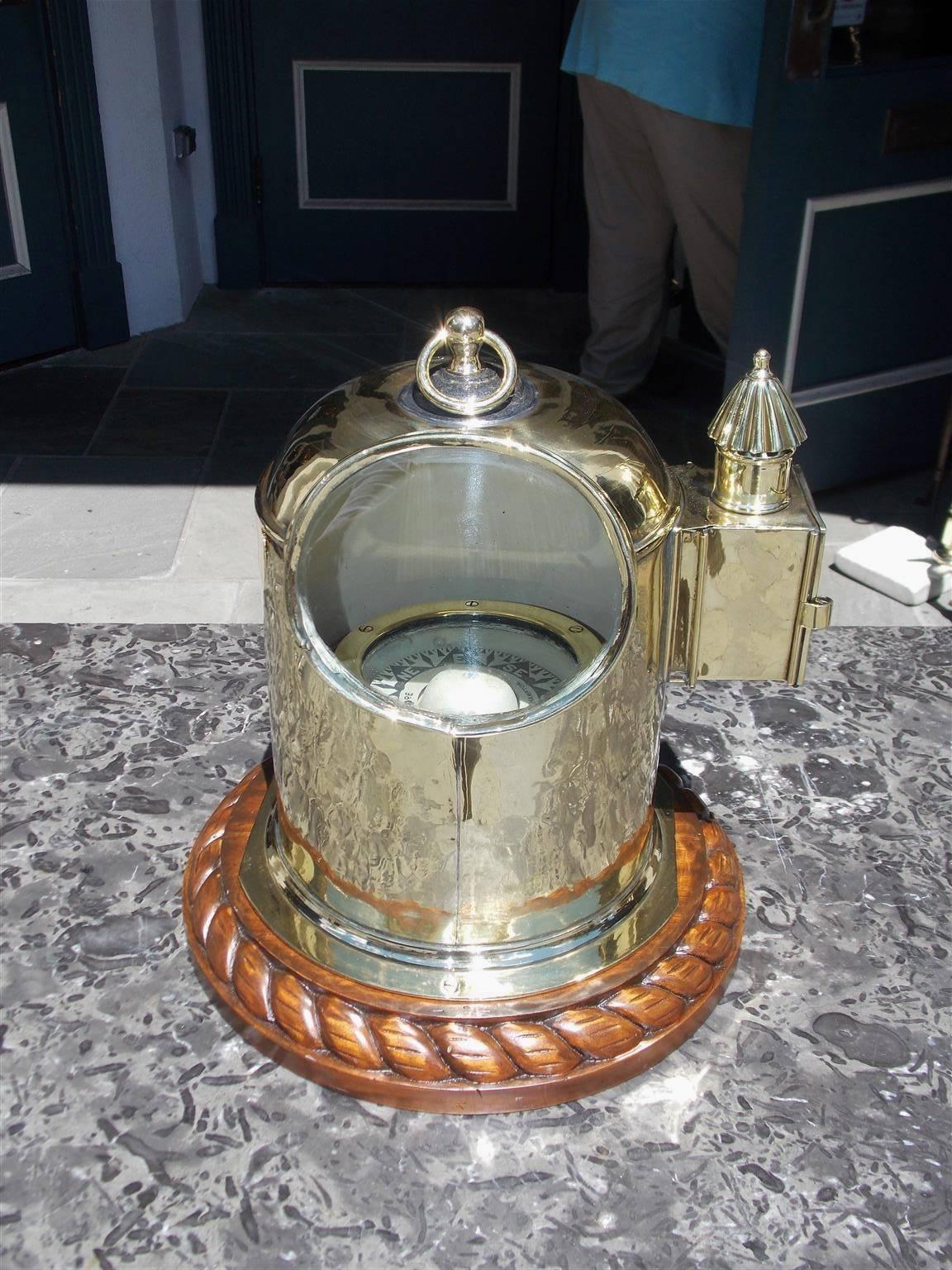 English yacht binnacle mounted on a mahogany rope motif base, oval glass viewing port, with the original removable brass vented side light and carrying handle. Binnacle is fitted with an interior compass submerged in alcohol signed Cope,