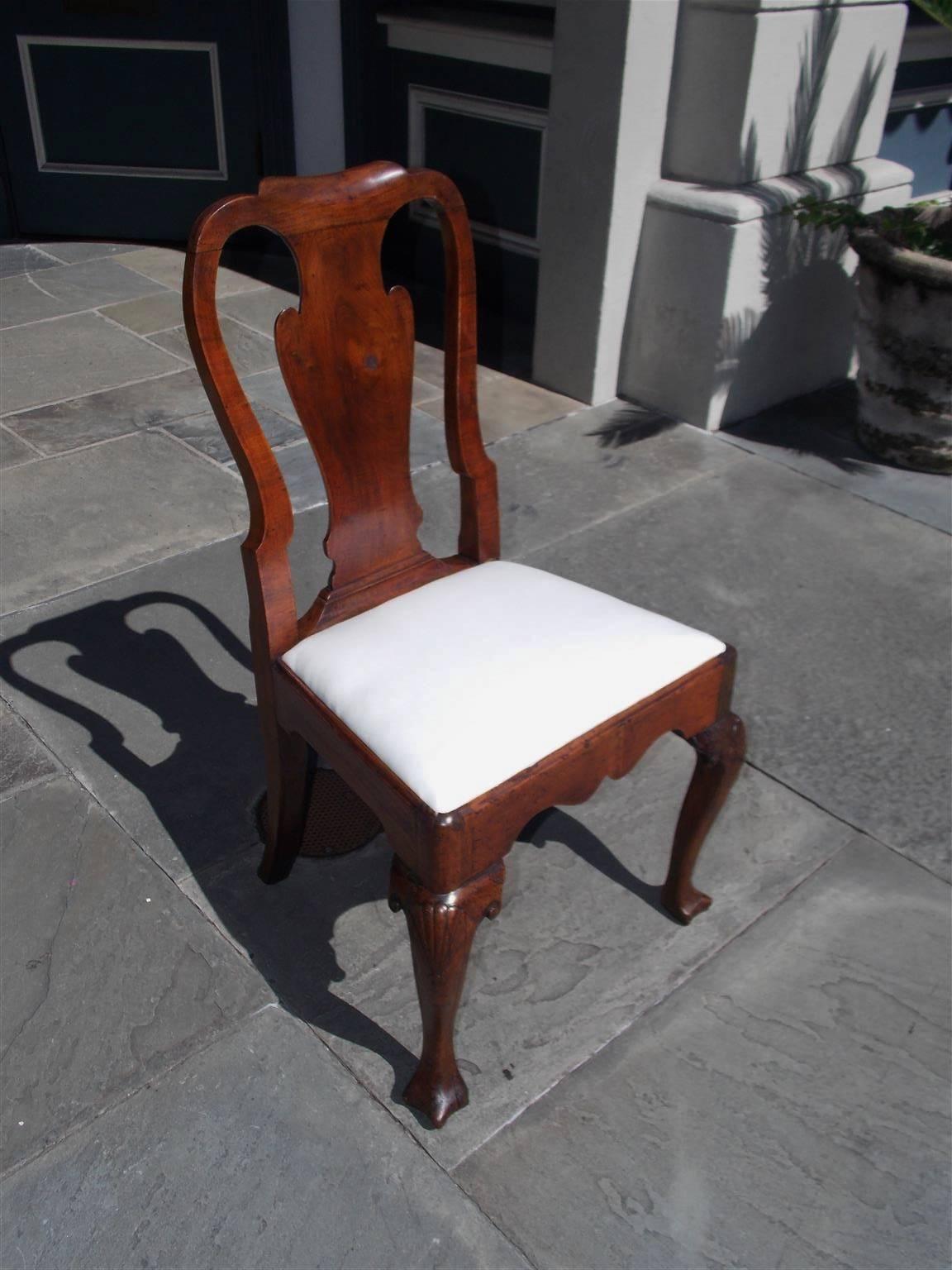 American walnut desk chair with carved scrolled rails, vase formed shaped splat back, scalloped carved skirt, carved shell on knee, and terminating on the original Drake feet, Philadelphia, Early 18th century. Chair retains the original seat frame