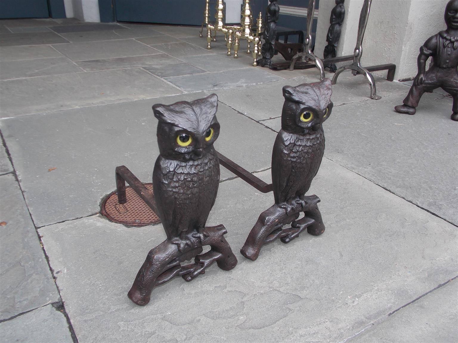 Pair of American cast iron owl andirons with the original glass eyes perched on tree limb motif, Boston, Early 20th century. Leg depth can be adjusted if needed.