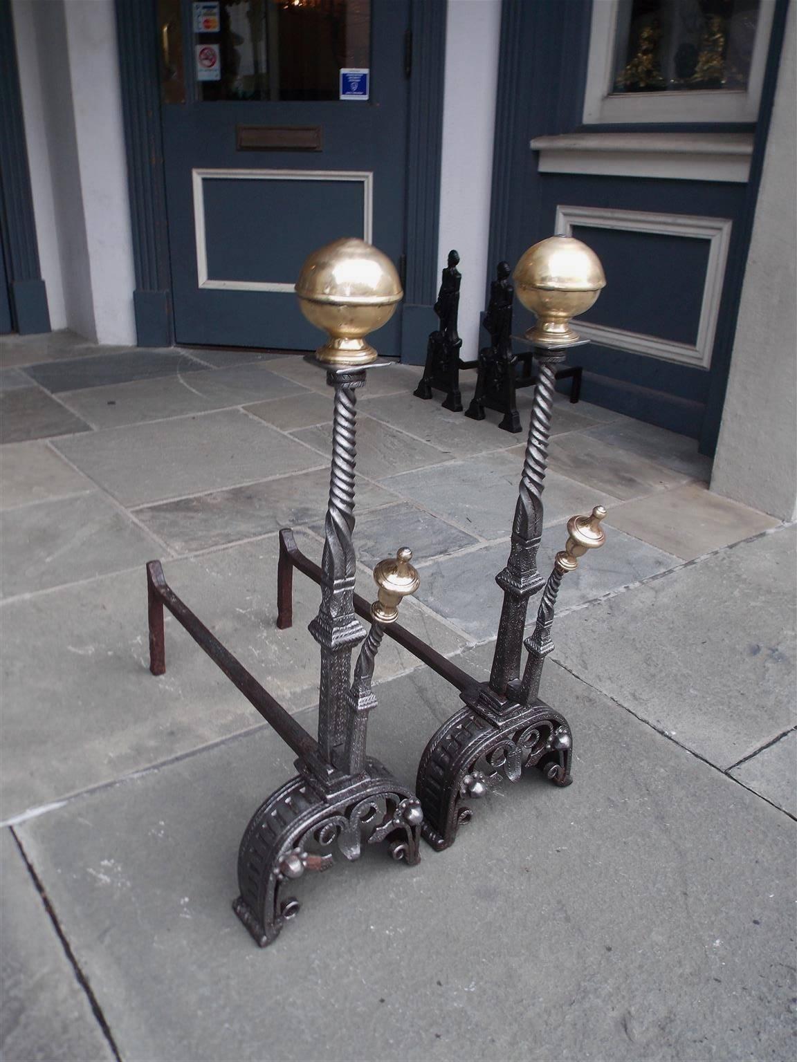 Pair of English brass ball top and wrought iron hand chased andirons with centered spiral twisted columns, matching spiral brass urn finial spit hooks, and terminating on the original scrolled decorative chased floral feet, Late 18th century. Depth