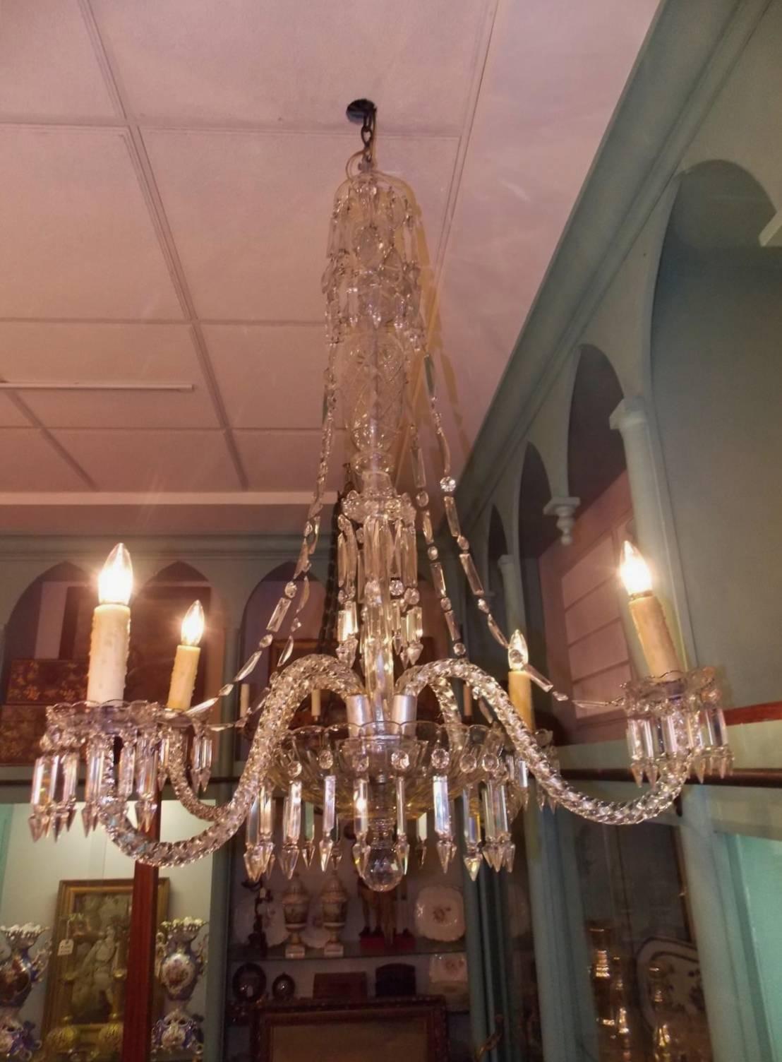 English cut crystal water fall chandelier with a centered bulbous crystal column, four scrolled spiral arms, cascading connecting prisms, and terminating with a large cut crystal bowl and faceted ball finial. Late 19th Century. Chandelier was