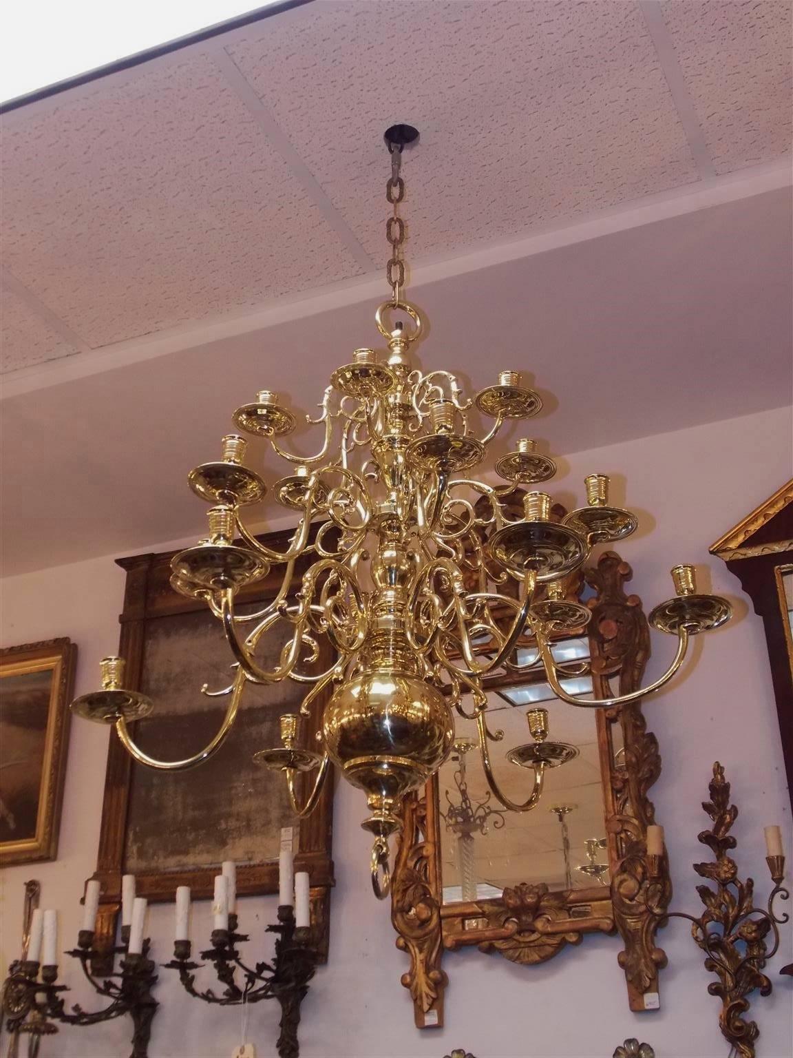 Dutch Colonial brass three-tier brass eighteen light chandelier with scrolled decorative arms, original bobeches, centered bulbous column, and terminating on a lower ball with ring finial. Candle powered and can be electrified if desired, Mid-18th