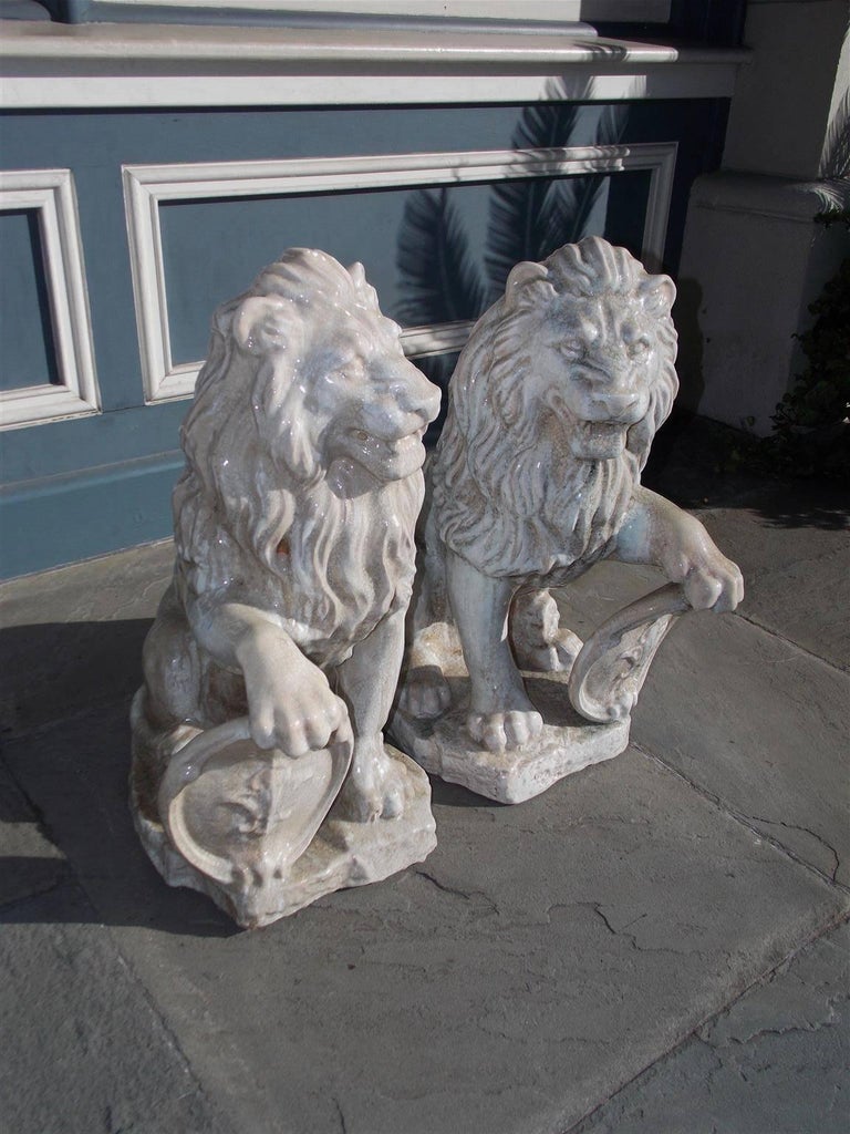 Pair of French Glazed Terracotta Lions Grasping Fleur De Lis Plaques