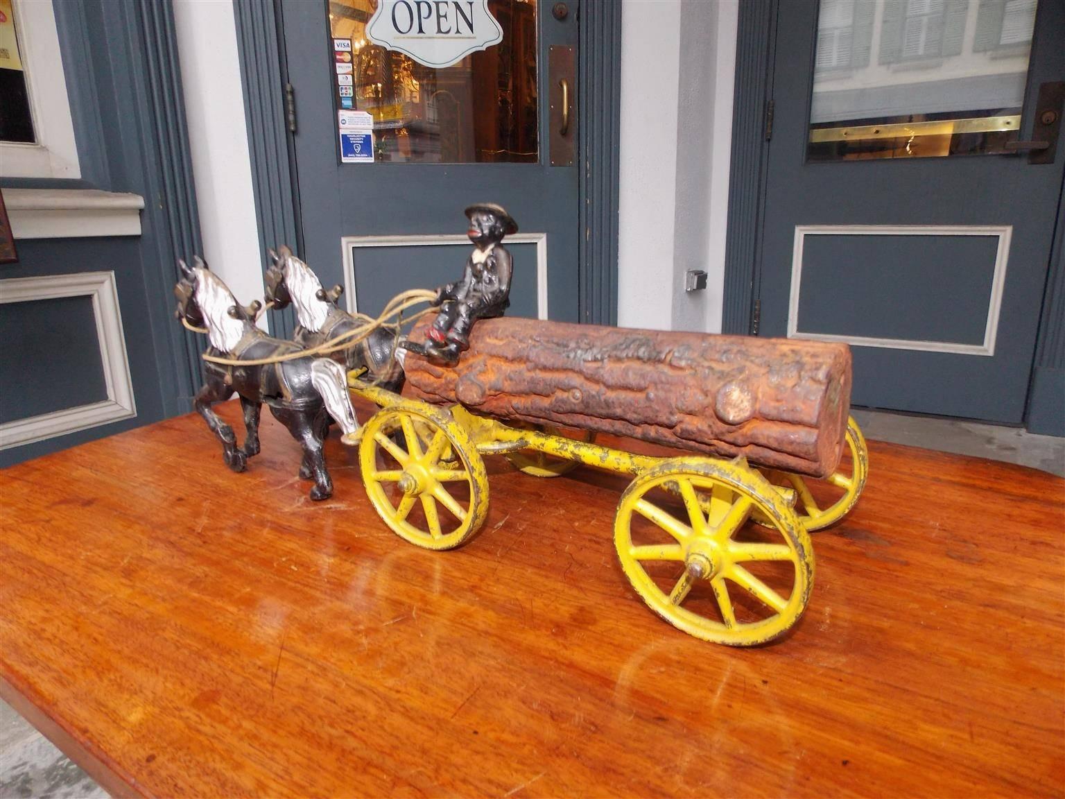 American cast iron poly chromed and painted pull toy with a log wagon, spoke wheels, and Negro man driving a team of horses, Kenton Toy Manufacturing. Circa 1894