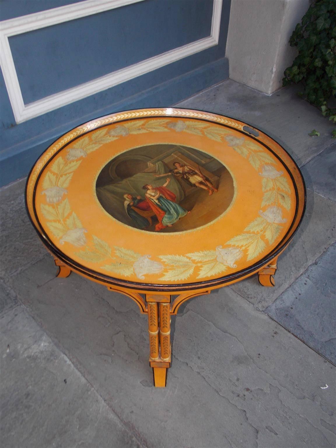 English Regency circular tole tray on stand with centered roman figures, floral ebonized borders, side handles, and resting on a painted carved faux bamboo floral stand with the original stretchers, Early 19th Century.