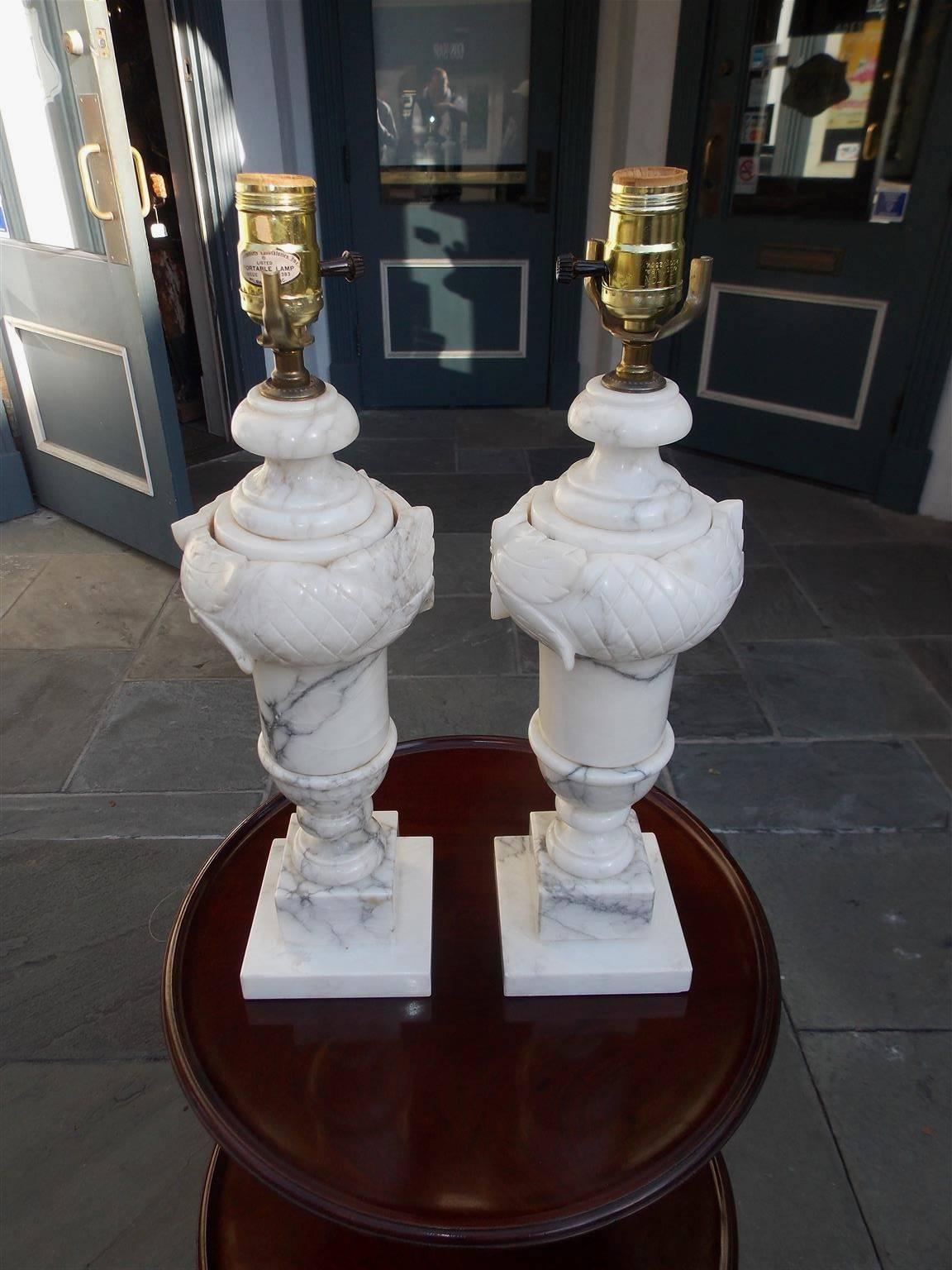 Pair of Italian hand-carved Prussian marble lamps with carved floral motif, centered urn column, and terminating on a two-tiered step back squared base, Late 19th century.
   