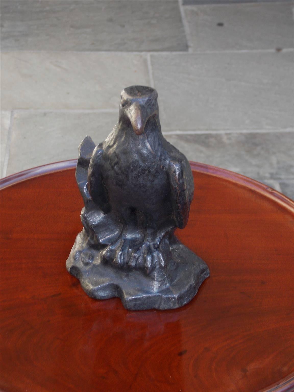 Scottish cast iron and hand-painted raven doorstop standing on rocky plinth base with centered incised space for holding door, Late 19th century.  