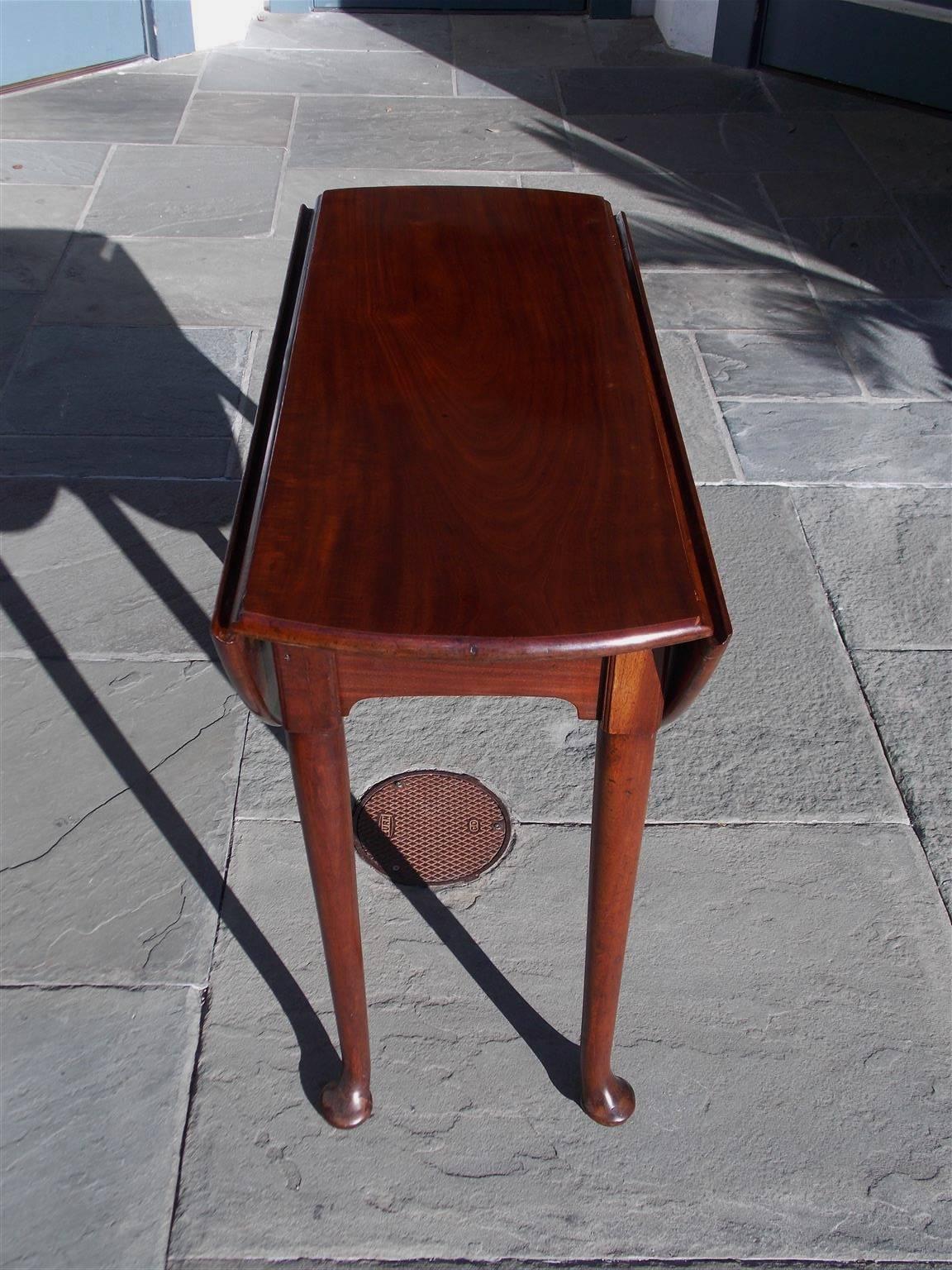English Queen Anne Cuban mahogany drop-leaf occasional table with two leaves supported by swing out gate legs, carved centered skirts, and terminating on the original tapered rounded legs with pad feet, Early 18th century. Secondary wood consist of