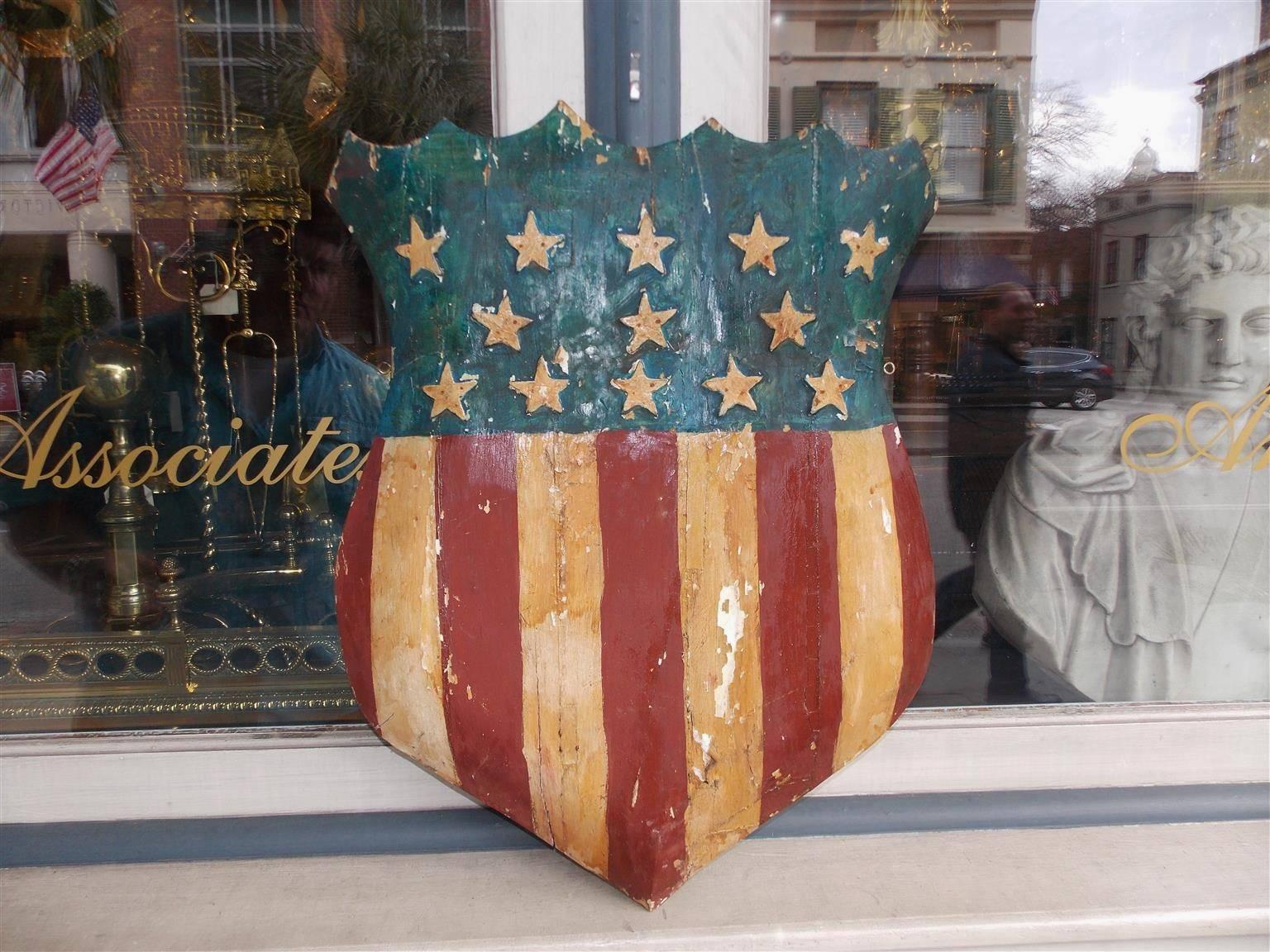 American hand-carved wood patriotic shield with hand-painted red, white, & blue stripes.  13 raised stars as well, 19th century.