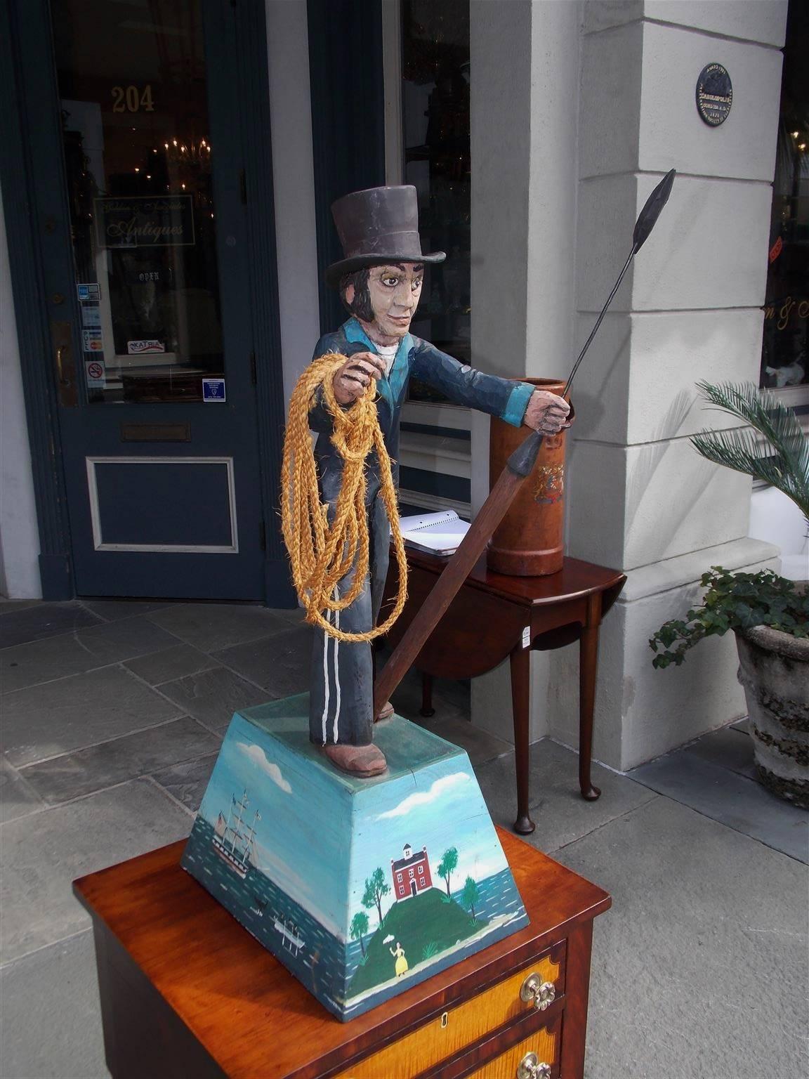 American hand-carved figural and painted nautical sculpture of Whaler. The wheel man is standing on a raised plinth holding a whaling iron, rope, and was used as a trade sign for a supply shop. Signed W. Northey, 19th Century