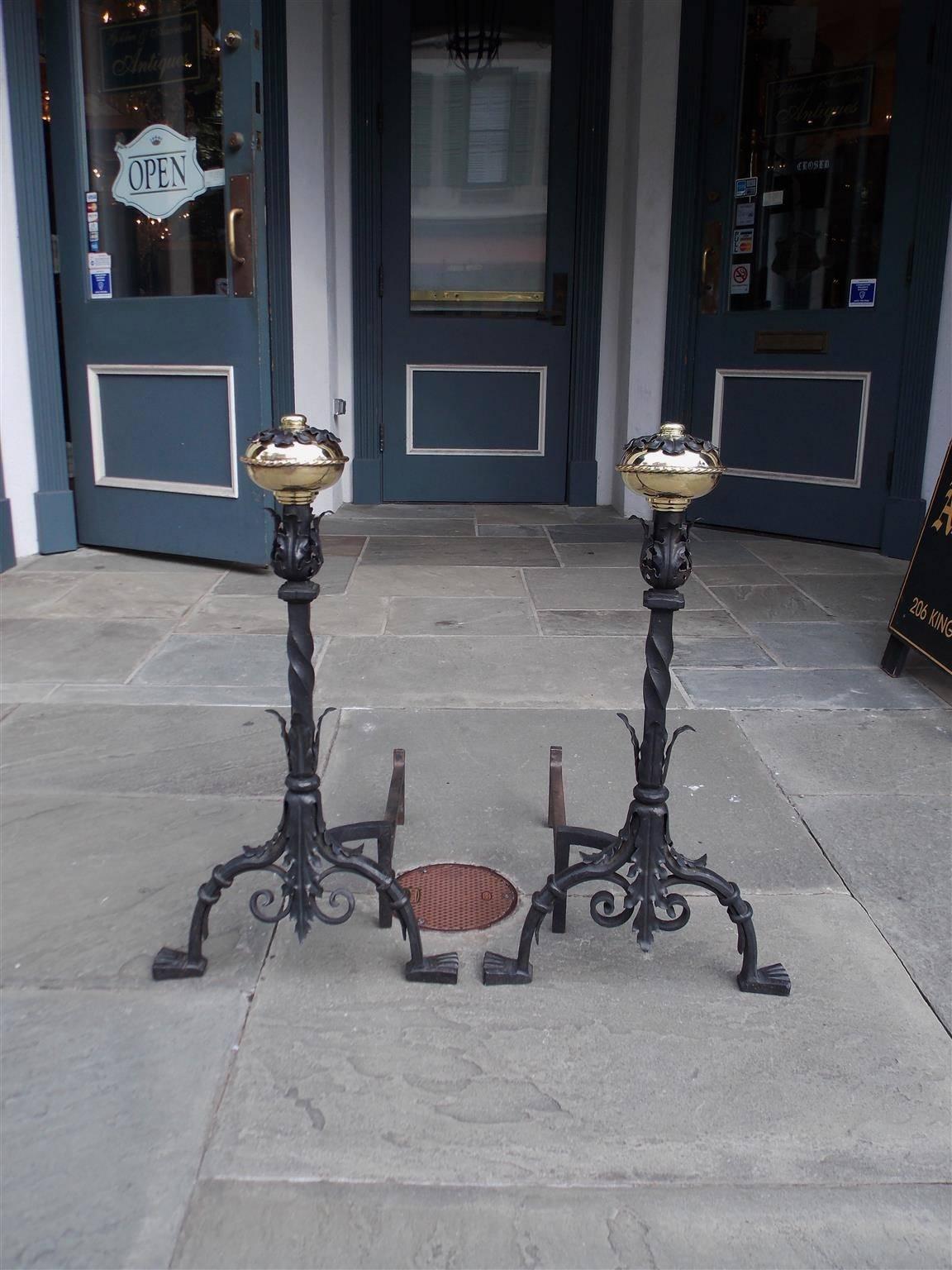 Pair of Italian brass floral acanthus and rope motif ball top andirons with wrought iron twisted column, acanthus centered plinths, pleasing decorative scroll work and terminating on stylized ringed paw feet, Early 19th Century.
