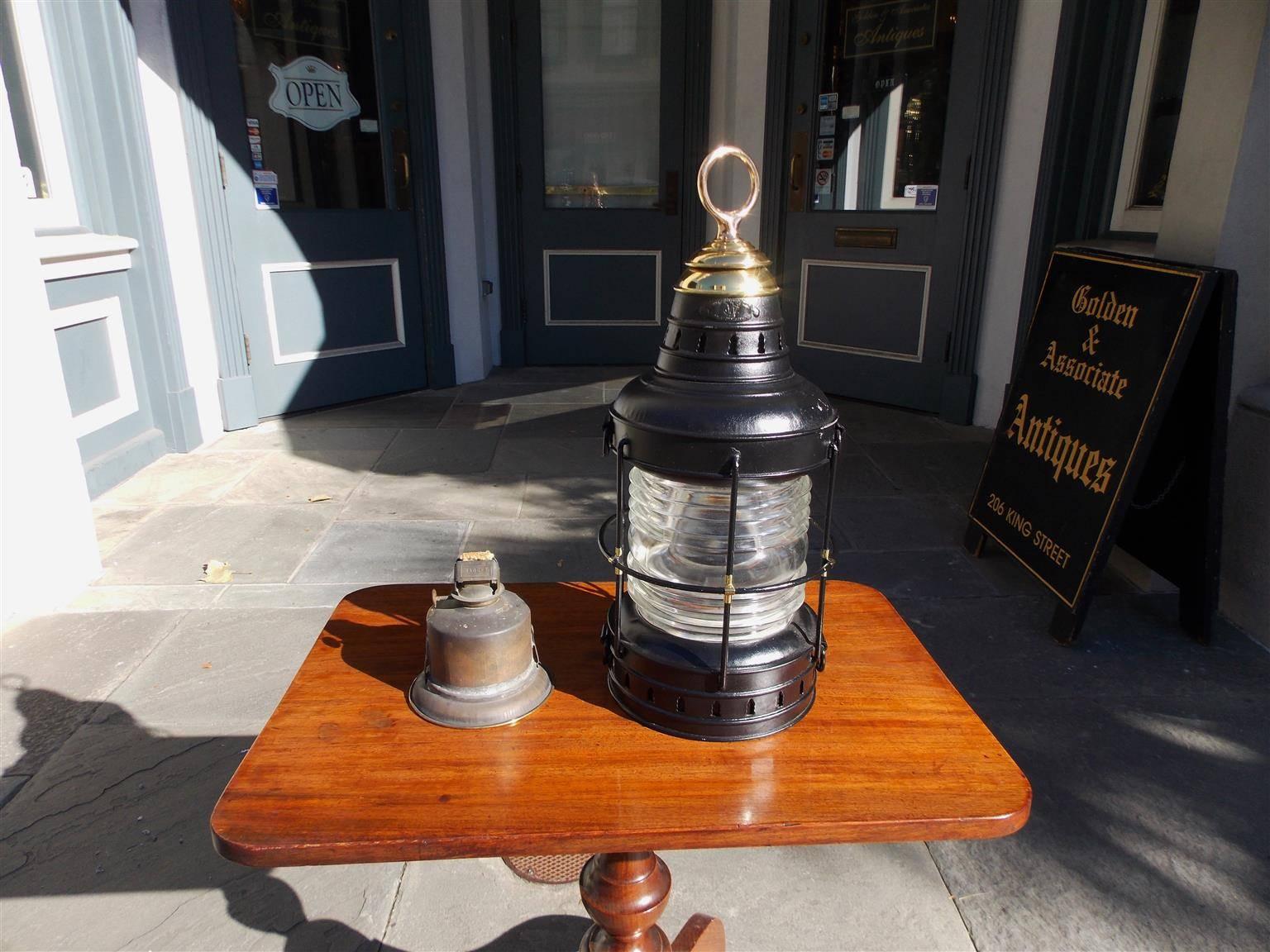 American painted polished steel and brass single ship anchor lantern with original Fresnel lense, hoisting ring,  protective cage, and original oil burner. Late 19th century Signed Wilcox- Crittenden and Company, Middle town,