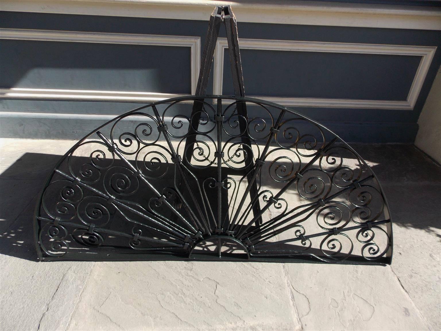 American wrought iron demi-lune ten panel window transom / gate with pleasing decorative scroll work motif.  Early 19th Century